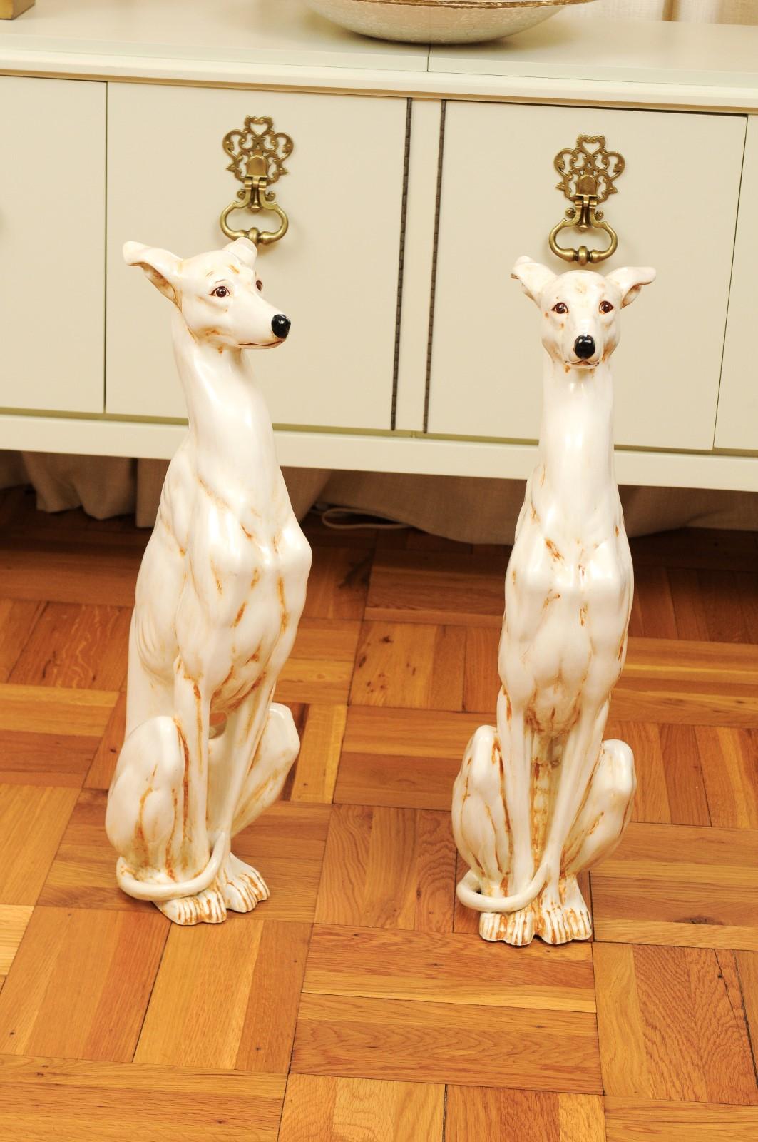 A fabulous pair of large scale ceramic Whippet sculptures, Italy, circa 1970. Beautiful hand painted form with a subtle glaze accenting the sculpture detail. Slender and dramatic with lovely facial expression. The pair have aged to absolute