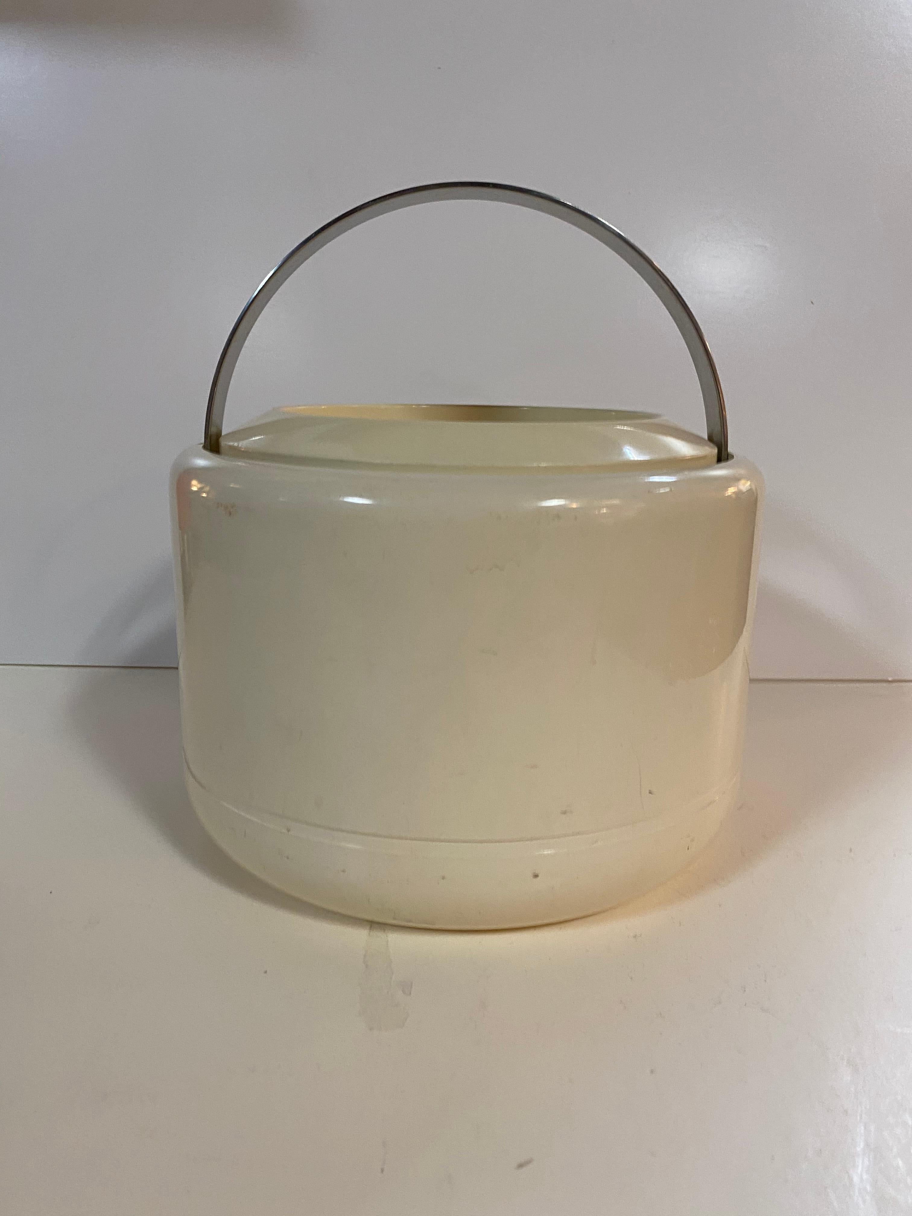 A cream / off-white ice bucket by Erik Magnussen for Stelton. Made of plastic and features a brushed metal handle that folds down when not in use and a removable top with self-handle. Danish, circa 1960.

Marked on underside; Stelton Design, Erik