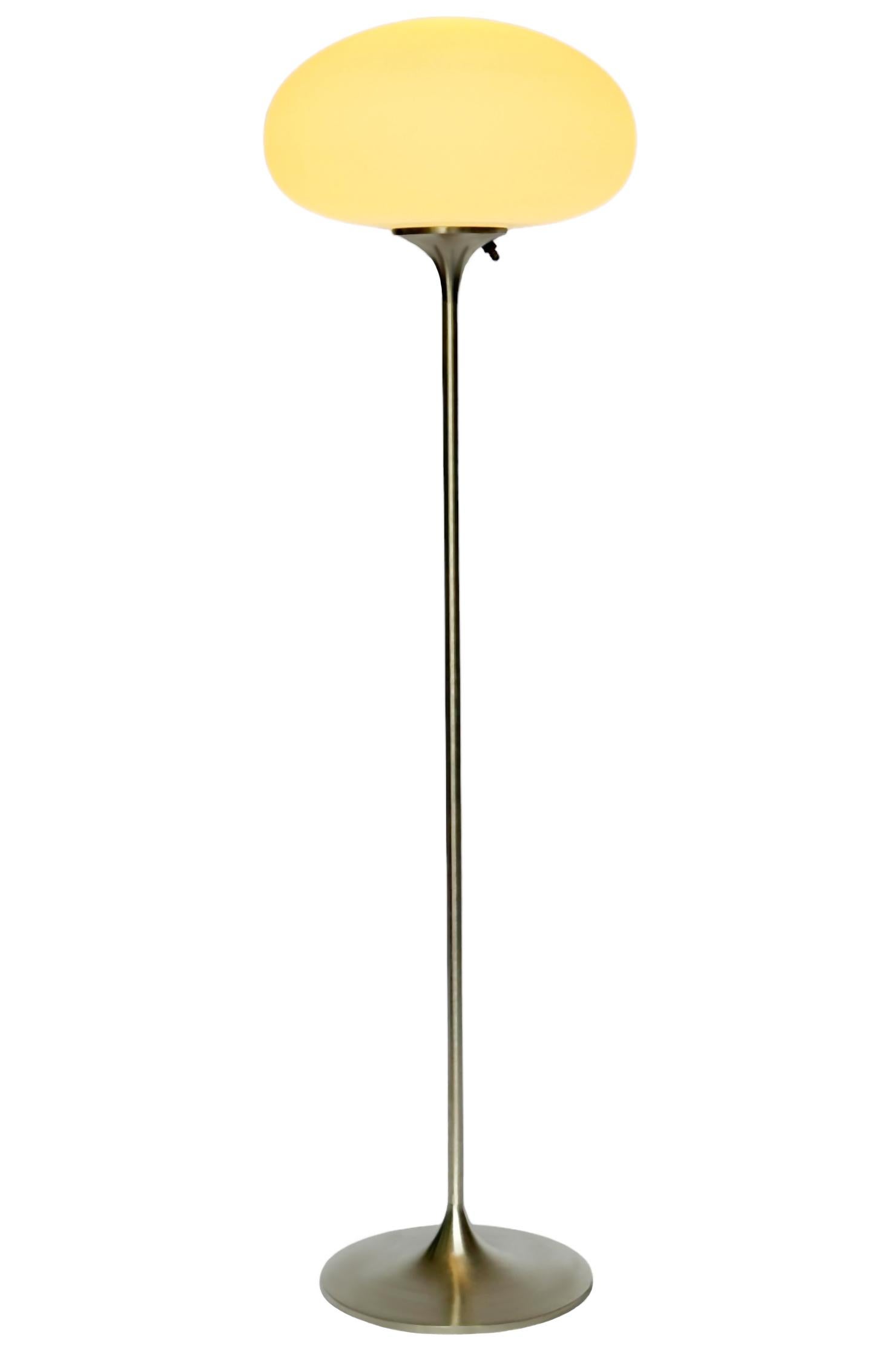 A sleek low profile floor made by Design-Line. It features a cast aluminum main base in a sculptural tulip form. The base is finished in a classic retro chrome finish. The frosted glass lamp is hand blown and gives off a soft warm filtered light. It