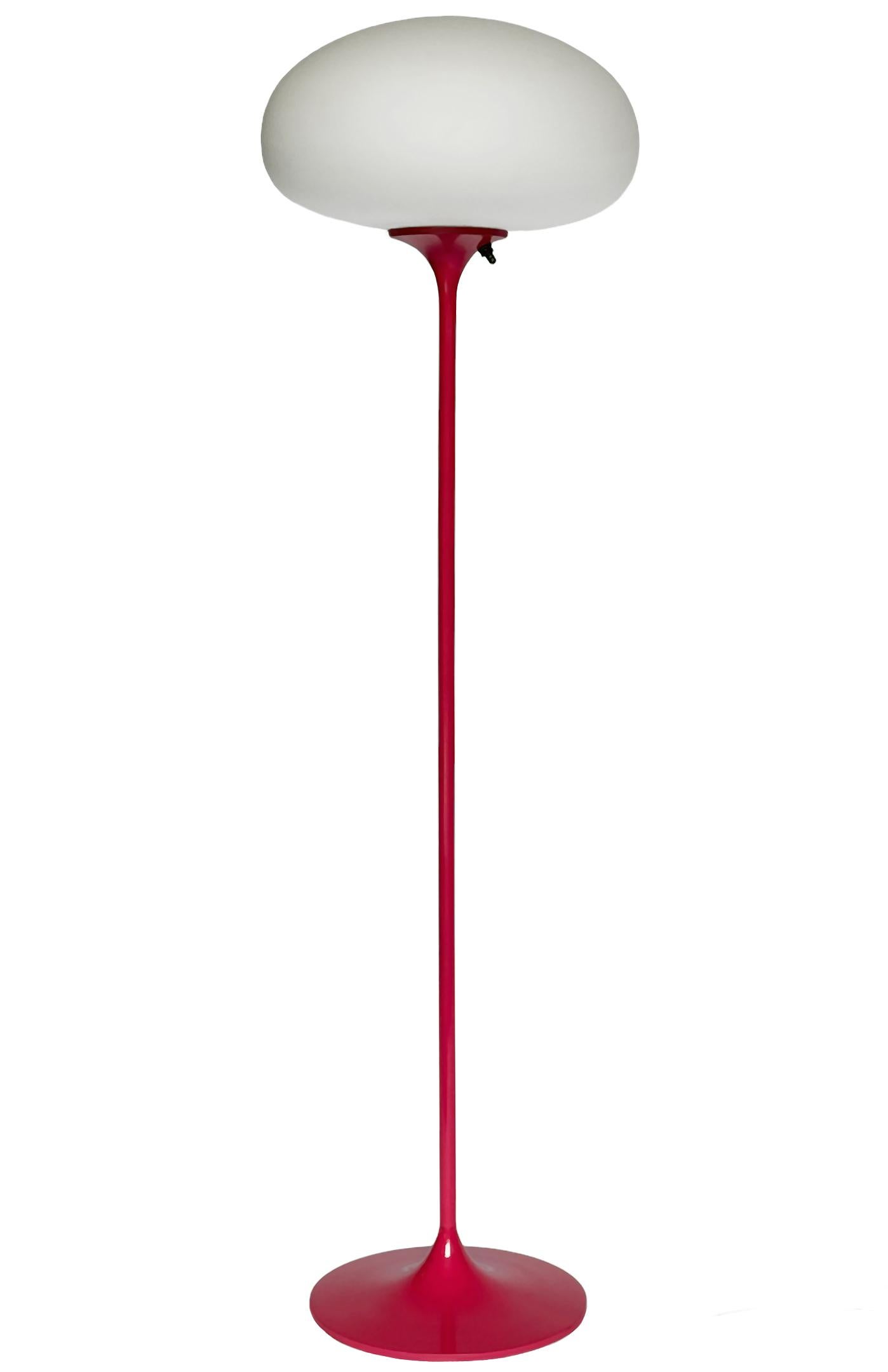 Un elegante pavimento a basso profilo realizzato da Design/One. Presenta una base principale in alluminio fuso a forma di tulipano scultoreo. La base è rifinita in un rosa retrò lucido. La lampada in vetro smerigliato è soffiata a mano ed emana una
