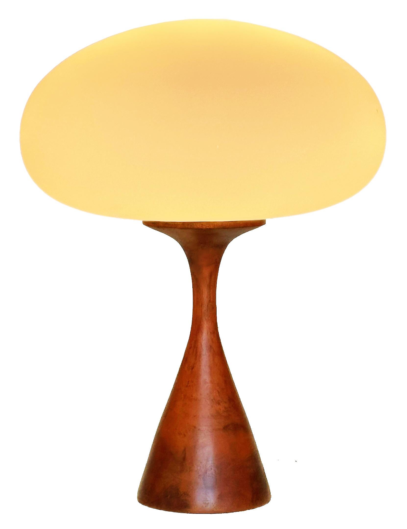THIS ITEM IS ELIGIBLE FOR FREE SHIPPING!

An artisan handmade table lamp by Design Line. It features a solid turned teak wood base with a handblown frosted white shade which gives off a soft warm light. The wood is natural teak, so color variations,