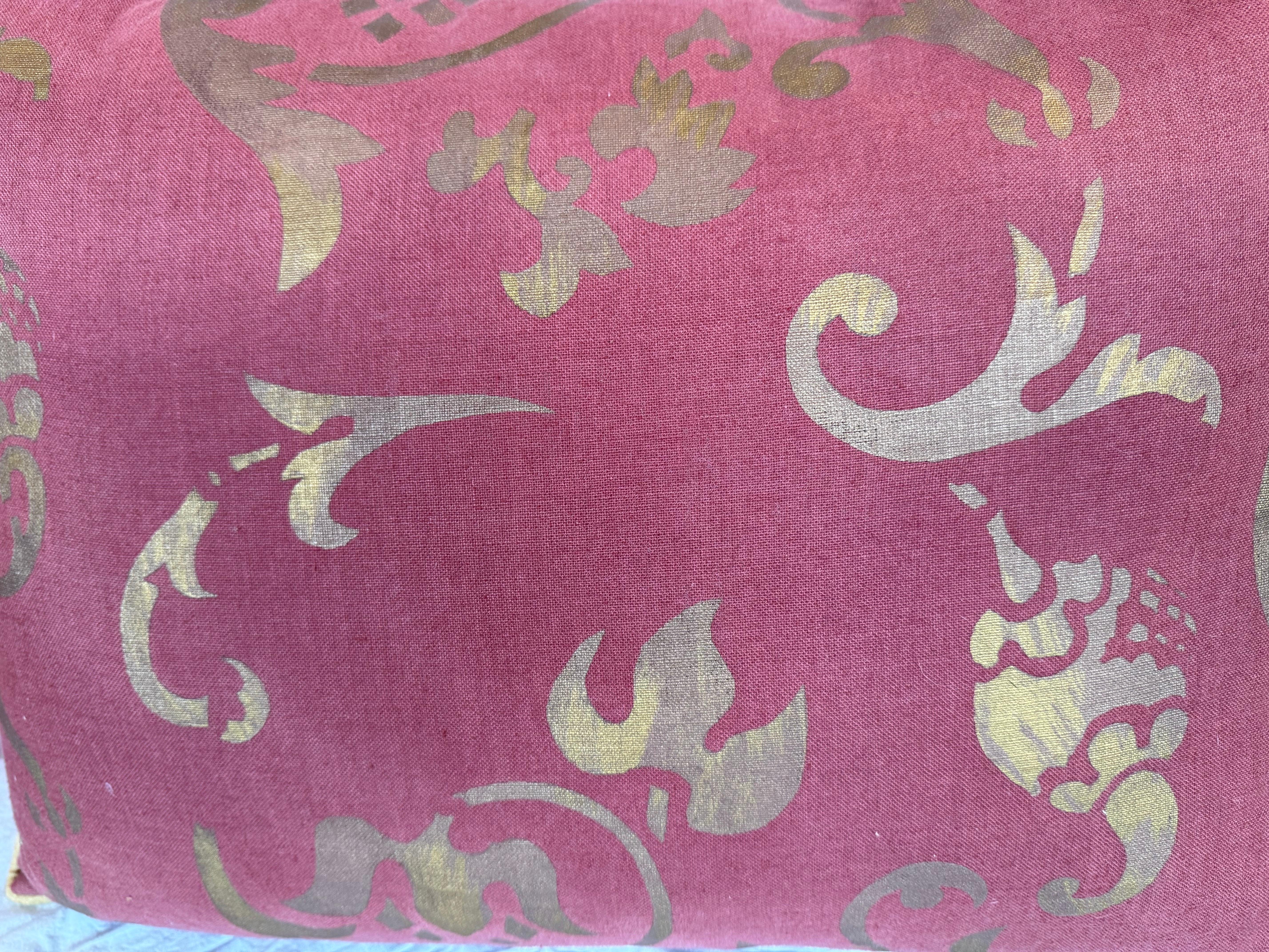 Questo cuscino accattivante è realizzato in un tessuto Nomi Textiles dalla texture ricca, con un motivo stencil dorato su uno sfondo di lino rosso mattone. I vorticosi motivi botanici e ornamentali astratti creano un aspetto dinamico e regale, in
