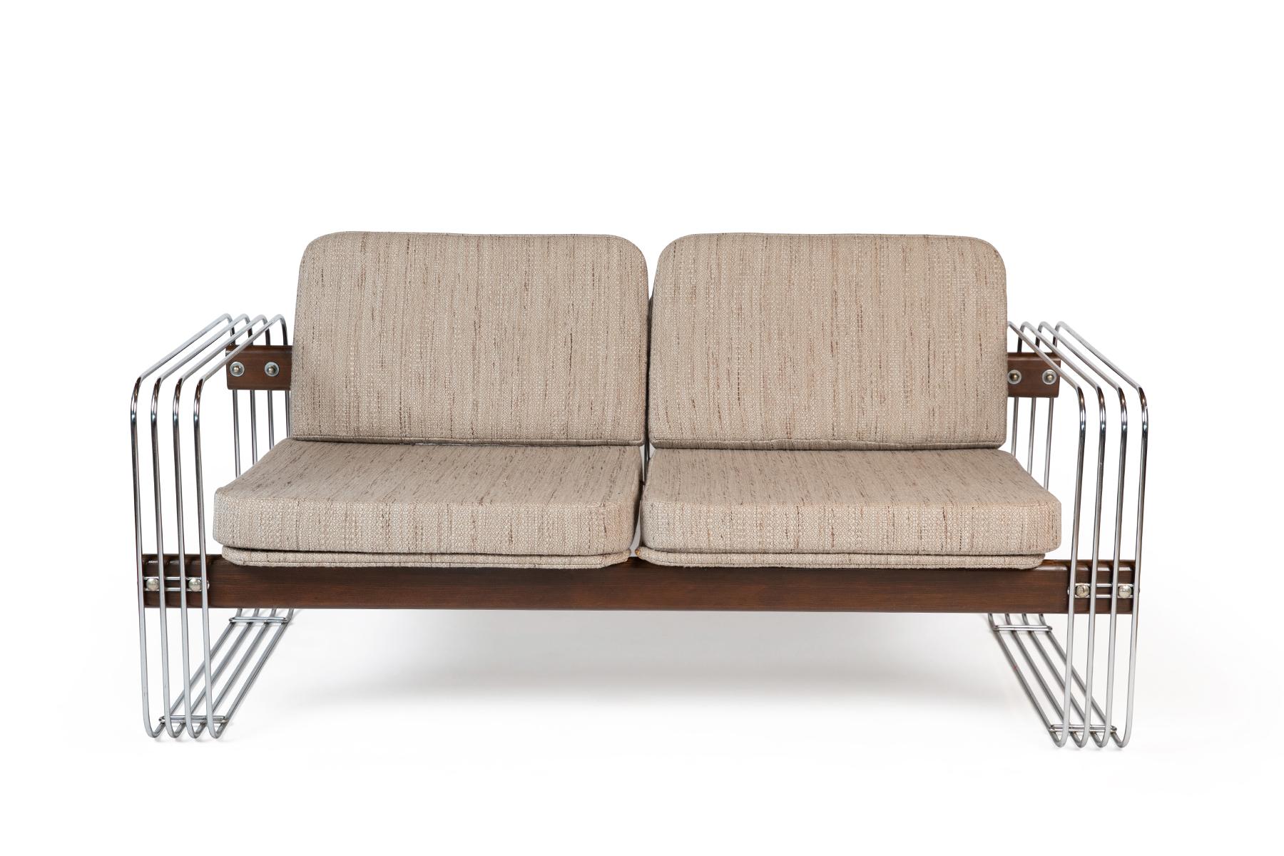 This light and airy modernist two-seater setee by Stendig in a neutral oatmeal Knoll Rivington upholstery is complemented by polished steel arm details and wood trim. Check out our other listing for a matching full-size Stendig sofa.