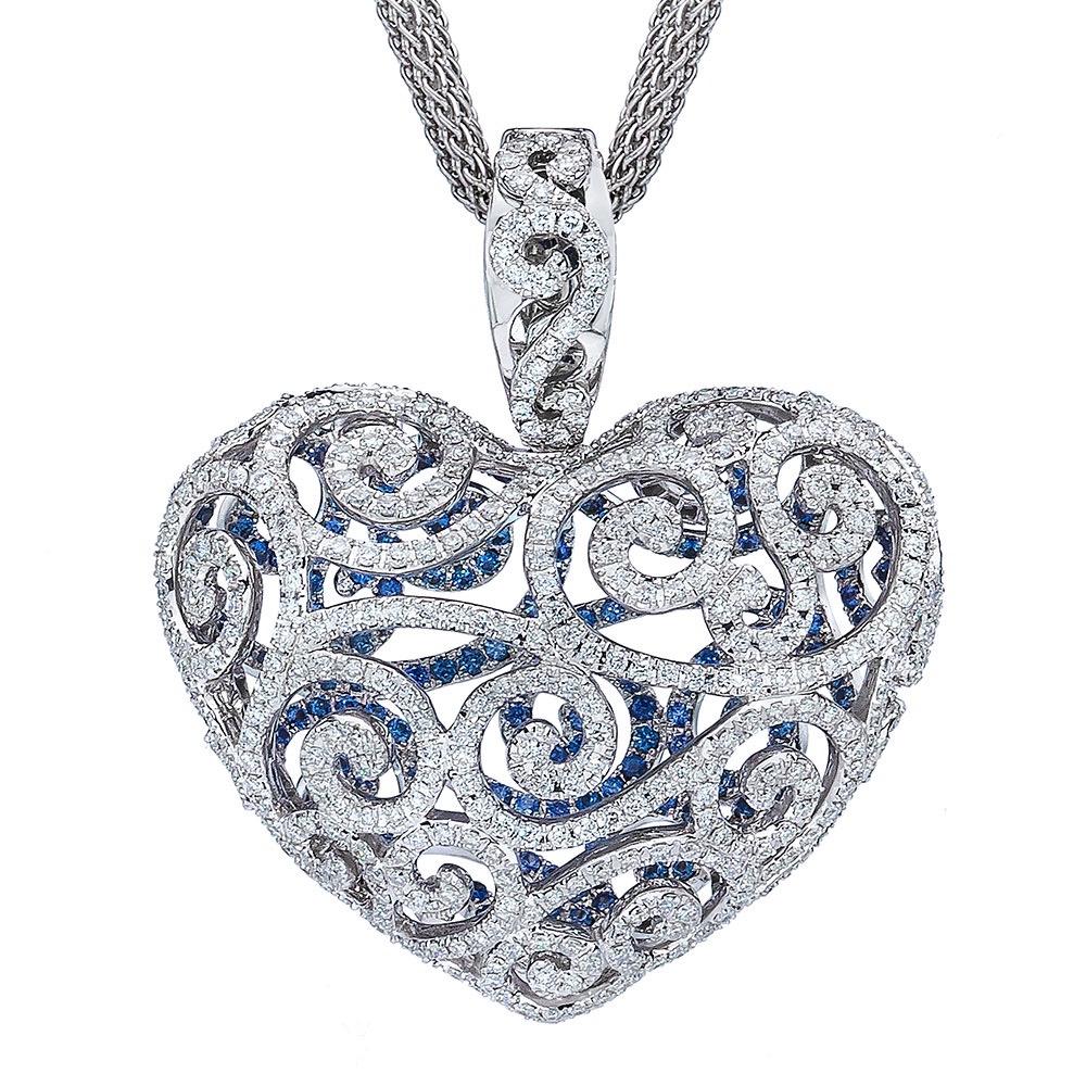 Designed with a Princess in mind, this 18 karat white gold Diamond heart pendant shows meticulous craftsmanship. The front of the puffed heart is pave set with round Diamonds in an open worked scroll pattern. The open work allows you to see inside