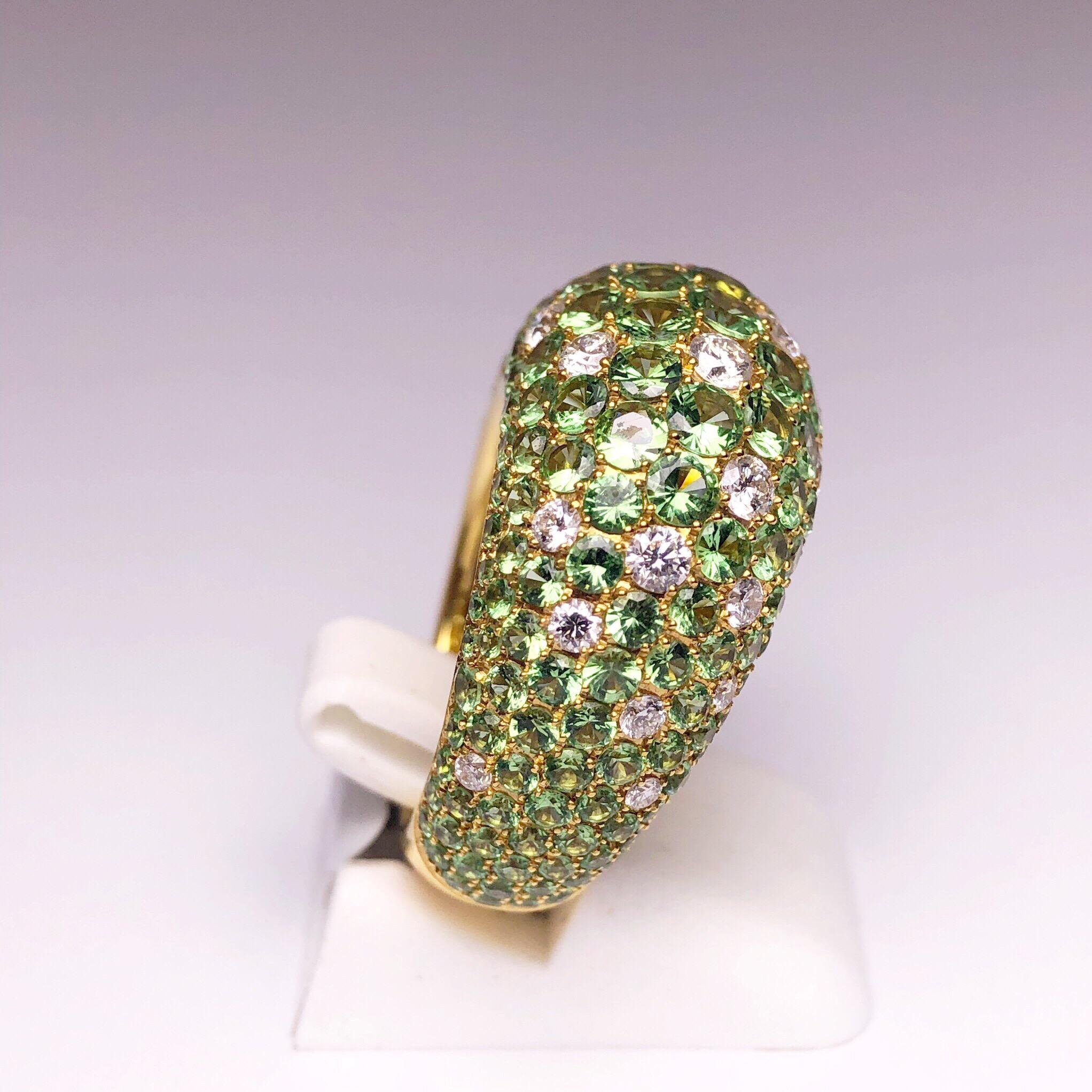 Crafted by the renowned Stenzhorn house of Jewellery, This classic 18kt yellow gold ring is pave' set with 8.20 carats of round green Tsavorite stones. Sprinkled throughout are round white brilliant cut Diamonds weighing .90 carats. The domed shaped