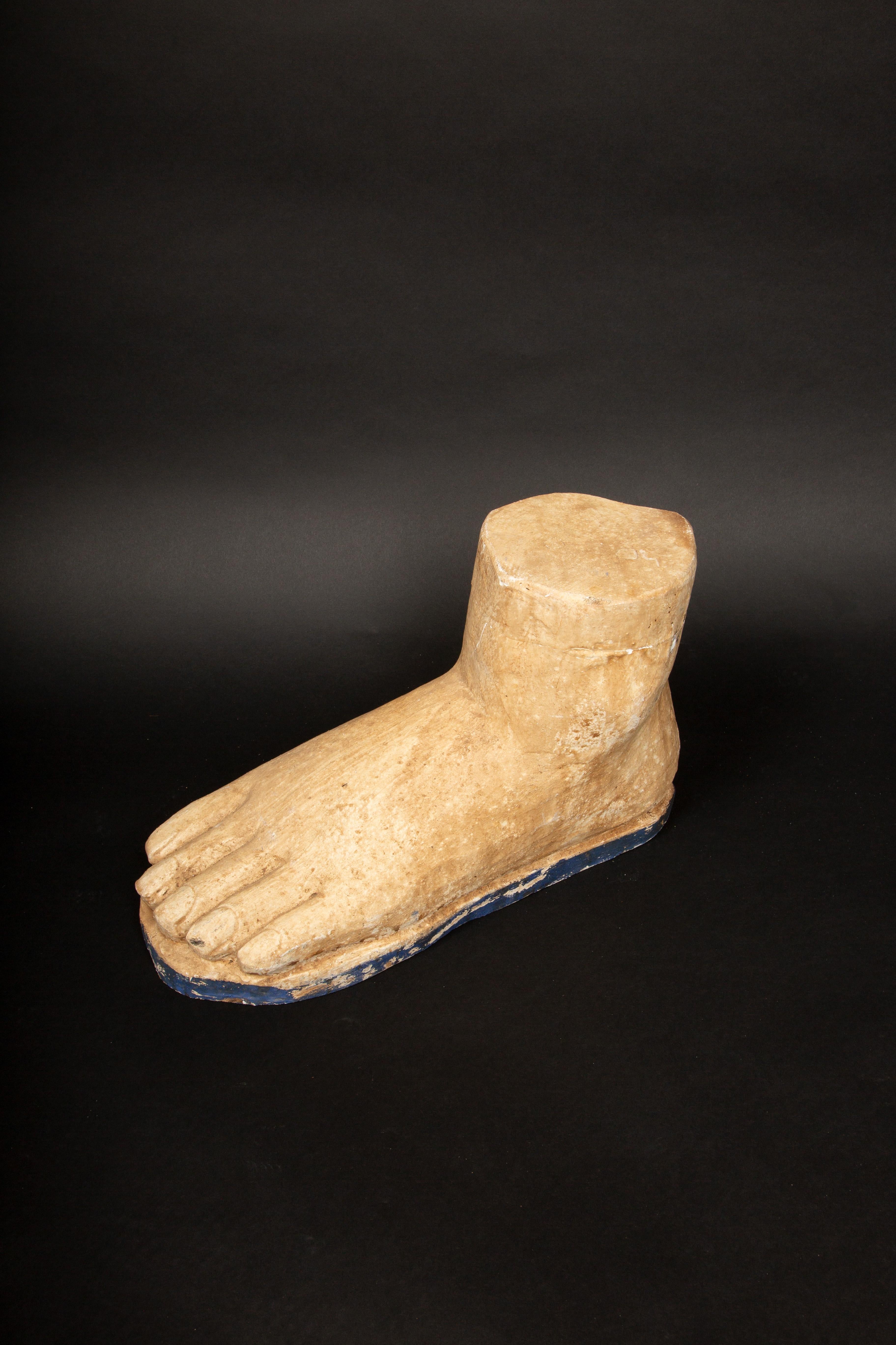 This large carved wooden foot showcases a stylized representation of the human form, with a focus on simplicity and an unembellished approach. The carving features defined toes and a slightly rounded shape, suggesting a blend of functional design