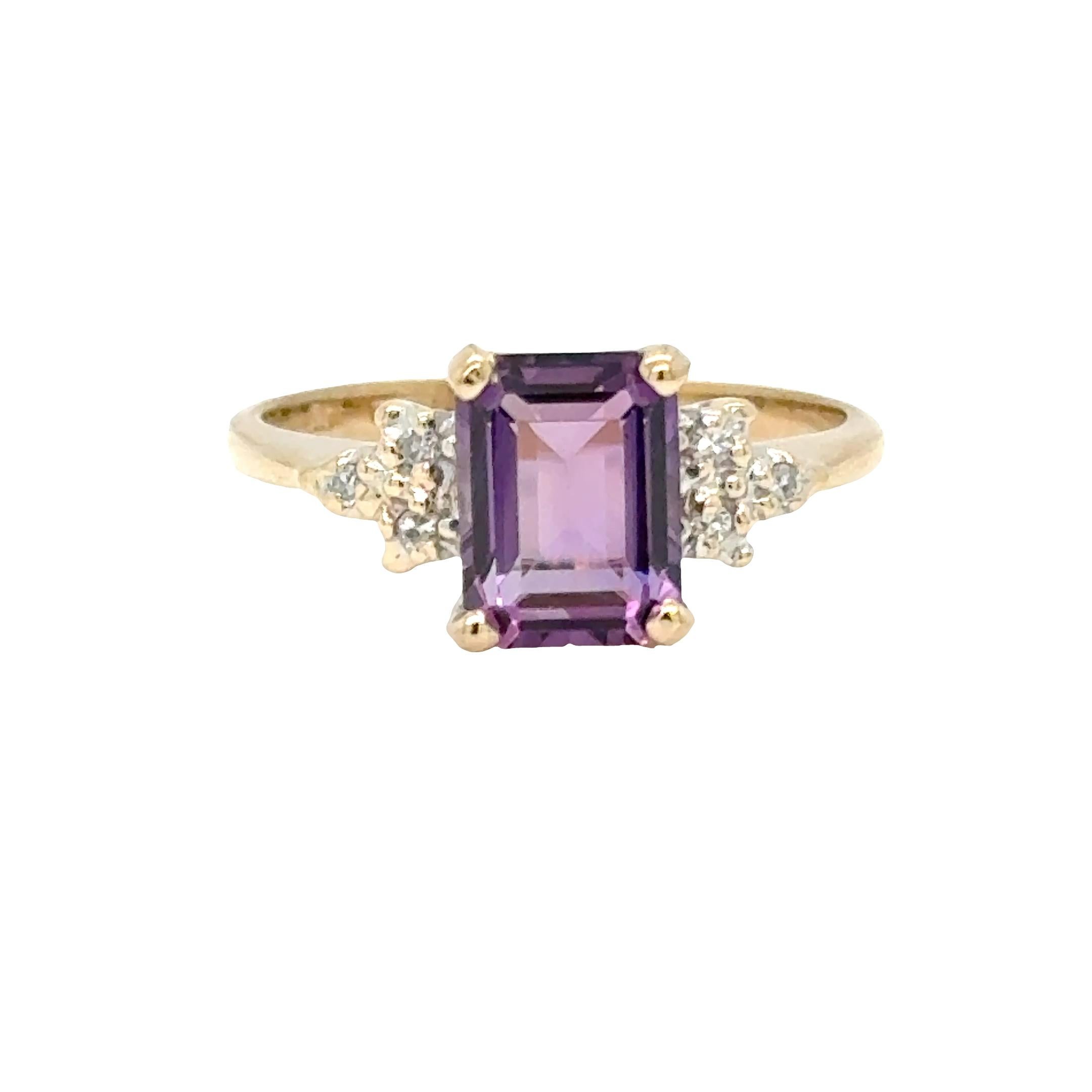 Eleganza classica con un tocco di colore.
Questo raffinato anello presenta un'ametista rettangolare tagliata a gradini (~0,50 carati) in una ricca tonalità viola, affiancata da tre diamanti rotondi su ciascun lato (~0,06 carati in totale) per il
