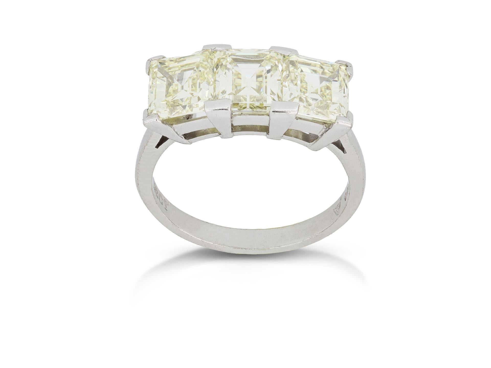 Step-cut diamond three stone ring. Set to center with a rectangular step-cut diamond in an open back claw setting with an approximate weight of 1.35 carats, flanked with two rectangular step cut diamonds in open back claw settings with a combined
