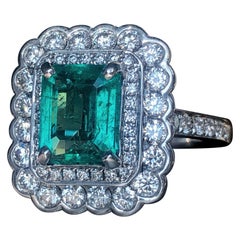 Step Cut Emerald with White Round Brilliant Cut Diamond Double Halo Ring