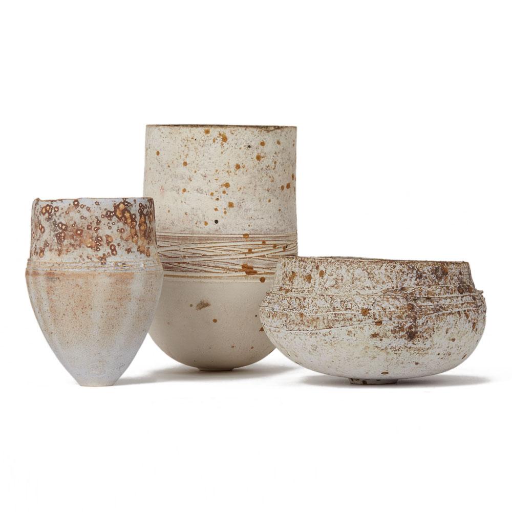 A stunning trio of finely made, contemporary, hand thrown Studio Pottery by Stephanie Black. The trio includes 2 vases and a bowl all of neutral tones with a matted textured finish with oxidised brown glazes creating a pitting effect. All 3 items