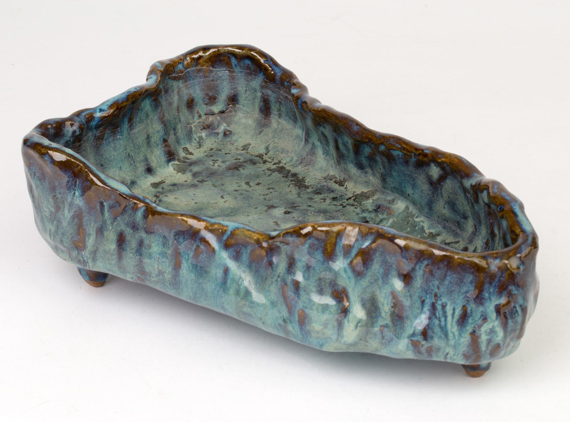 A stylish Brutalist sculptural form Studio Pottery open work bowl by Stephanie Kalan (1909-1978) probably dating 1953-1978. The bowl of elongated boat shape sits on a flat base and is formed in thick hand formed clay with a combed pattern natural