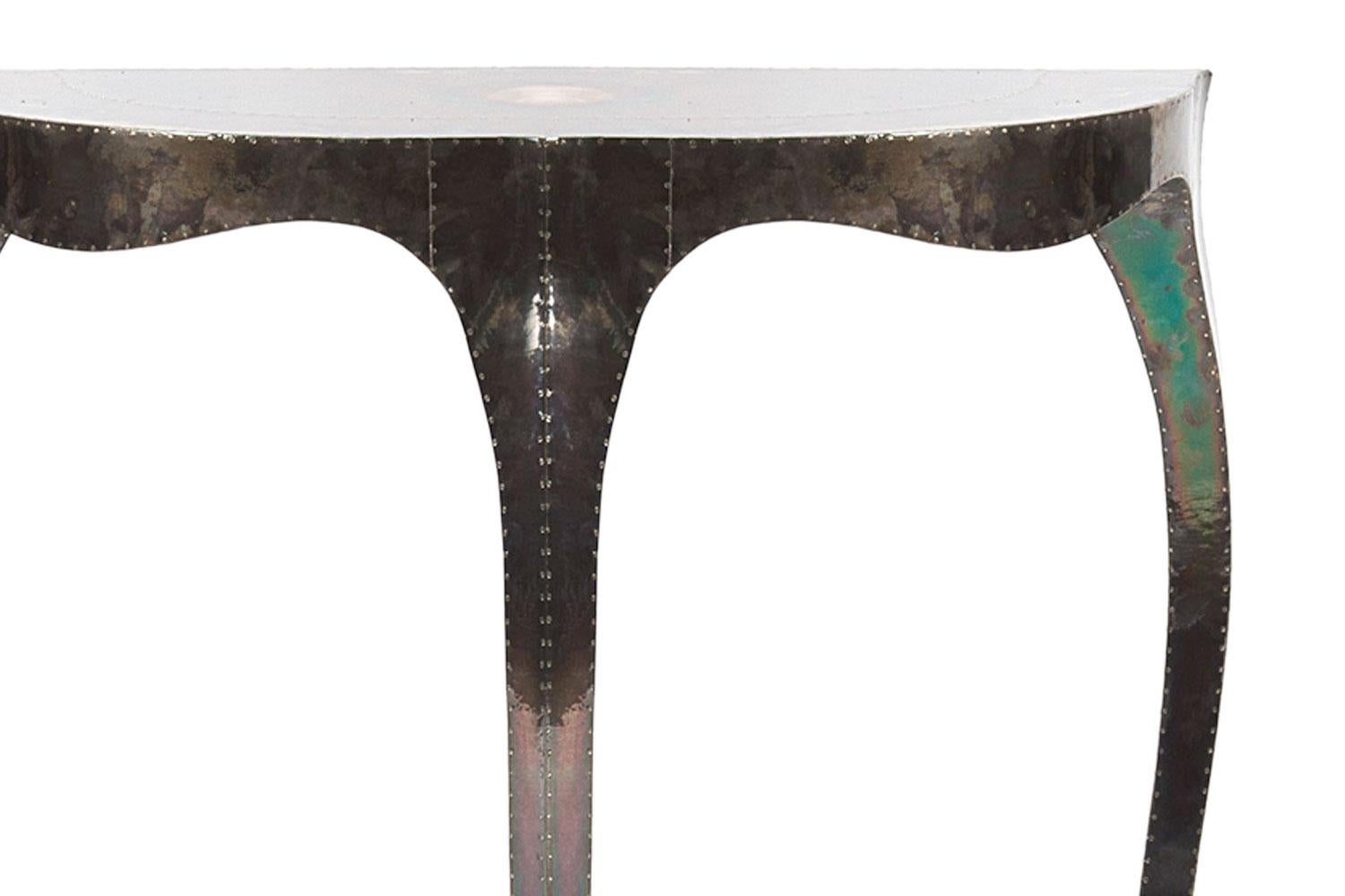 Silver Clad Louise demi lune console table by Stephanie Odegard

This console table is handmade and has a solid teakwood frame that is clad in silver and is part of the Stephanie Odegard Collection. This functional table is a great side table and