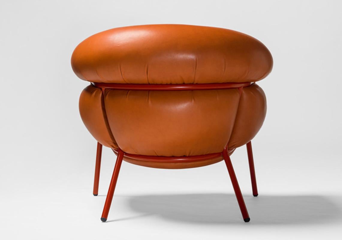 Armchair and foot stool designed by Stephen Bruks manufactured by BD Barcelona.

An iron tubular (25mm) structured armchair. Seat and backrest upholstered in leather.

The leather upholstery oozes over the bare iron structure to contrast with