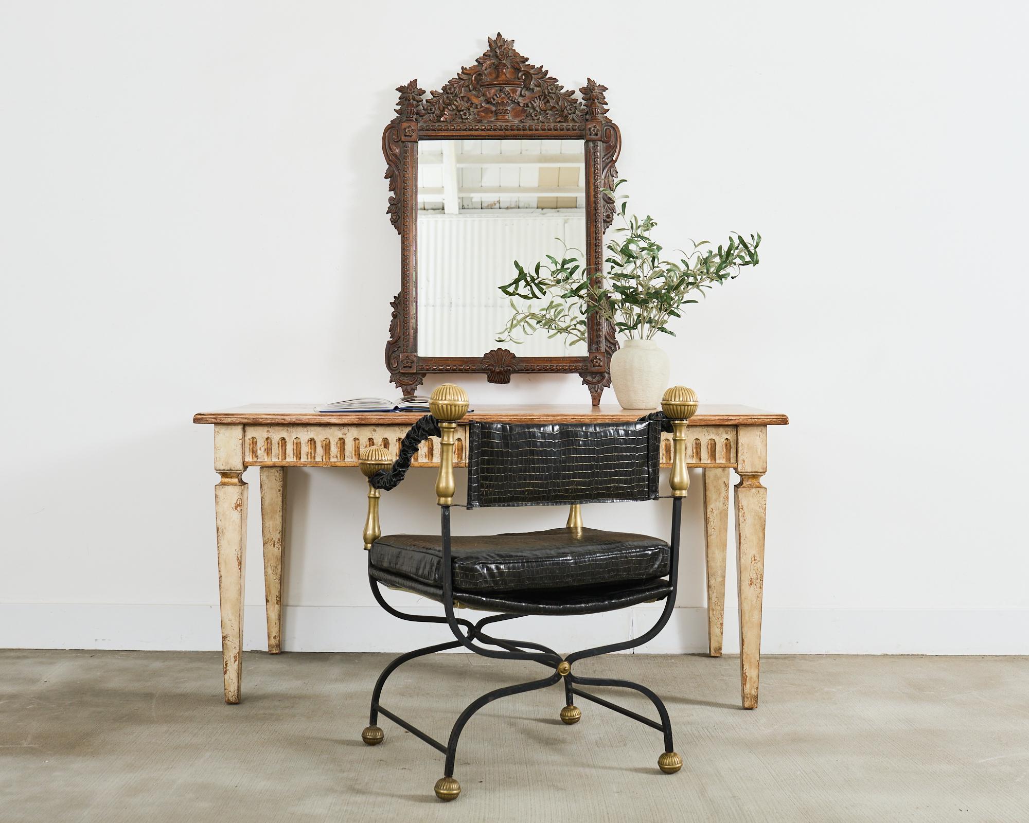 Distinctive hand-carved wall mirror by Stephen Cavallo, New York. The mirror features an intricately carved thick frame in the grand French Louis XVI taste. The top of the mirror is centered by a large neoclassical urn with ribbon swag and floral