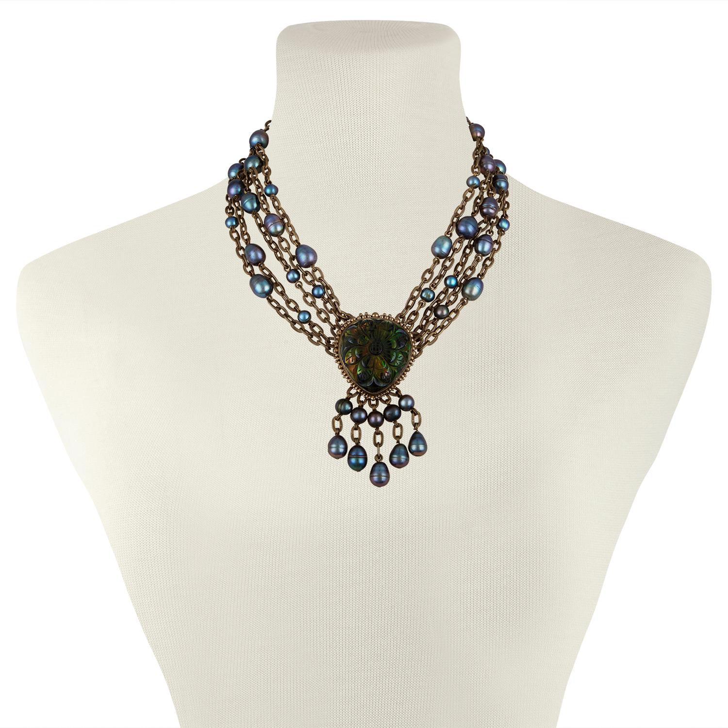 Bronze Stephen Dweck collar multi-strand necklace
Featuring carved fancy cut quartz over mother of pearl doublet
Baroque oval cultured pearl and toggle closure
The necklace measures 17.5