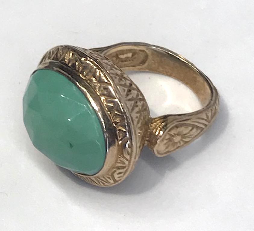 A Stephen Dweck ring with large faceted turquoise cabochon. The setting is intricately carved bronze and mounted with an approximately 13.5 x 18.5 mm turquoise cabochon stone. The inside and back mounting of the ring is also carved as well. Interior
