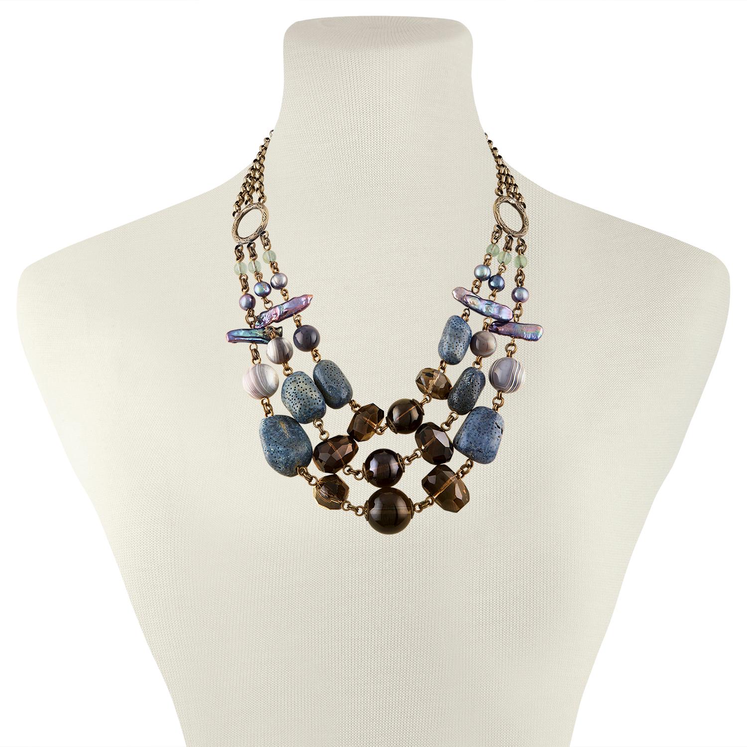 Stephen Dweck 3 Strand Necklace
The necklace is brass
There is blue coral, Smokey quartz, agate, pearls, etc.
The necklace is 19