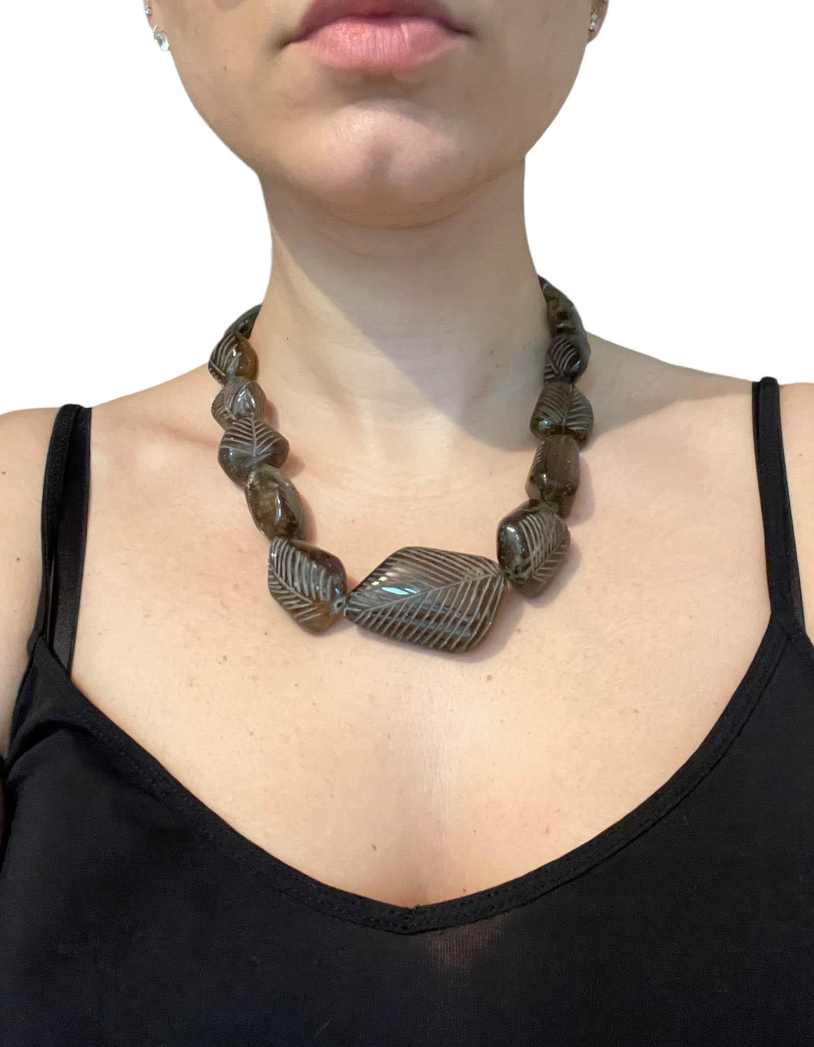 Stephen Dweck Smoky Topaz Carved Necklace.  Features graduated smokey topaz with leaf like carving.

Color: Brown
Metal: Brass
Materials: Smoky topaz
Hallmarks: 1991 Stephen Dweck
Closure/Opening: Toggle
Overall Condition: Very good/excellent. 