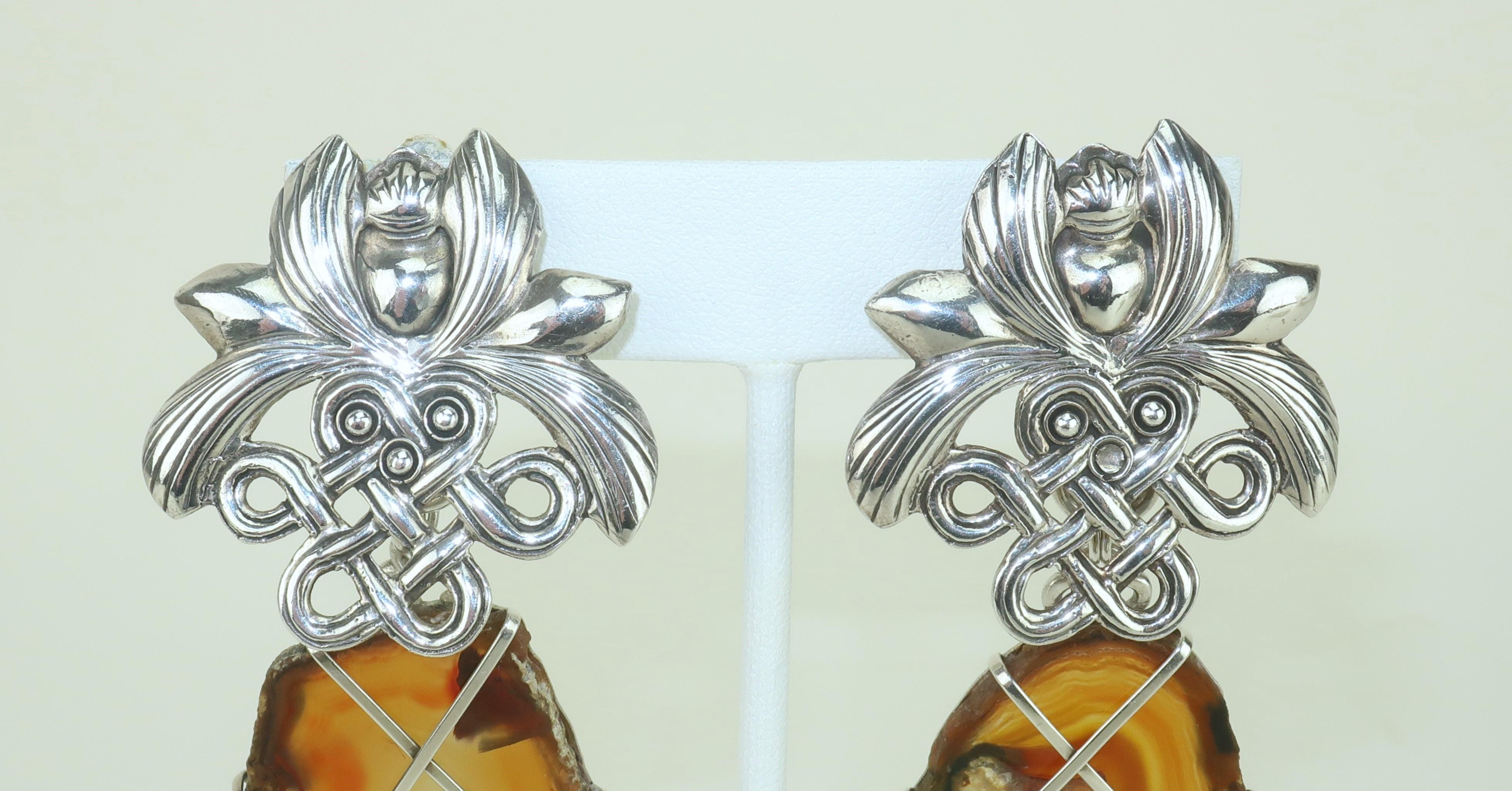 1989 sterling silver clip on earrings with an agate dangle by Stephen Dweck.  The ornate base has a knot and orchid design and the lattice frame around the amber colored agate dangle features a detailed scarab.  Beautifully made with hallmark at the