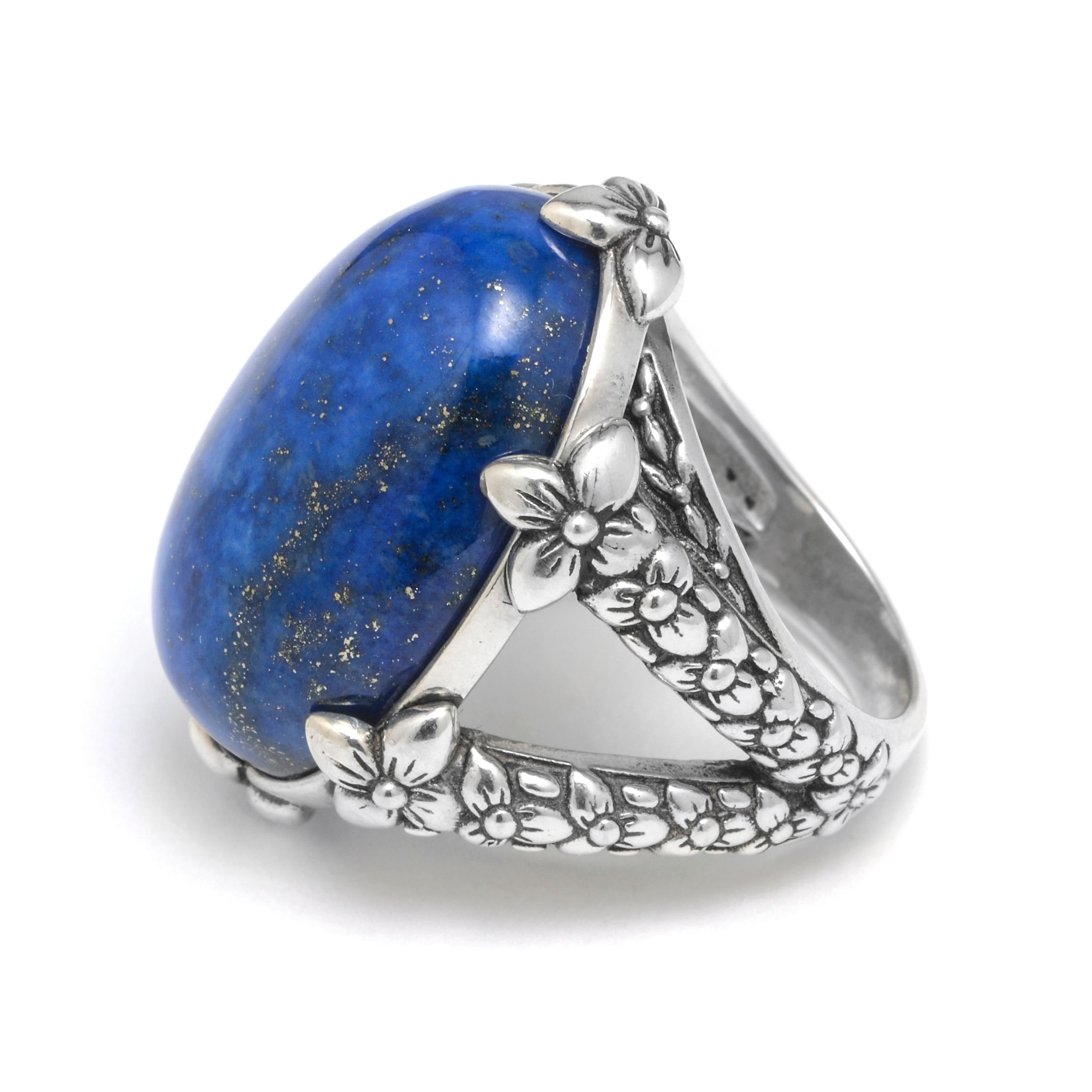 This bold Stephen Dweck Sterling Silver Statement Ring features a vibrant Blue Lapis cabochon (18mm x 26mm) held by floral shanks of sterling silver. Drawing inspiration from a love of nature and passion for art, each Stephen Dweck creation is a