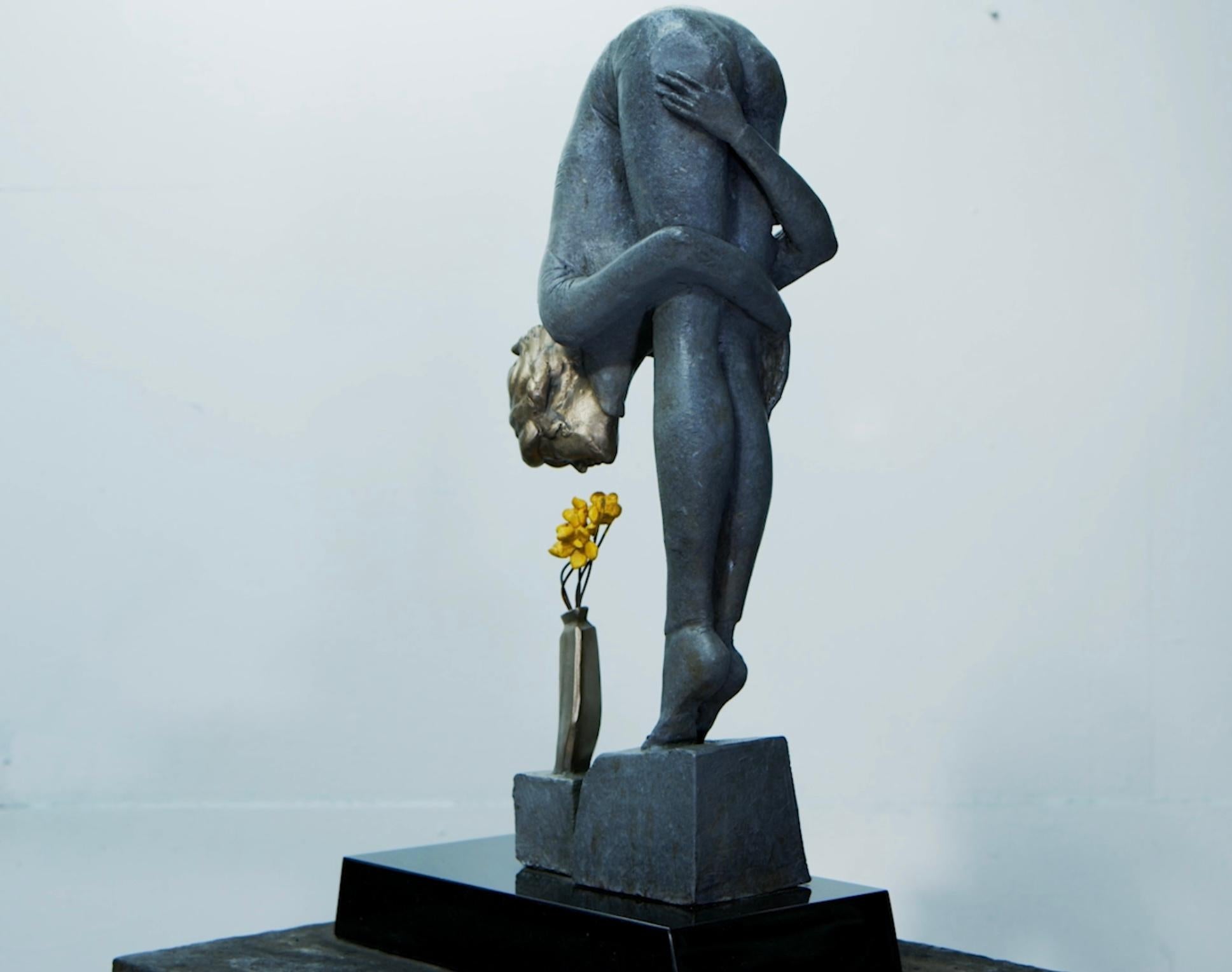 A bronze sculpture that depicts a girl sitting with her arms resting on her legs. The sculpture has a conceptual and figurative style, which means that it represents a real-life subject but also incorporates abstract or symbolic elements.

Artist