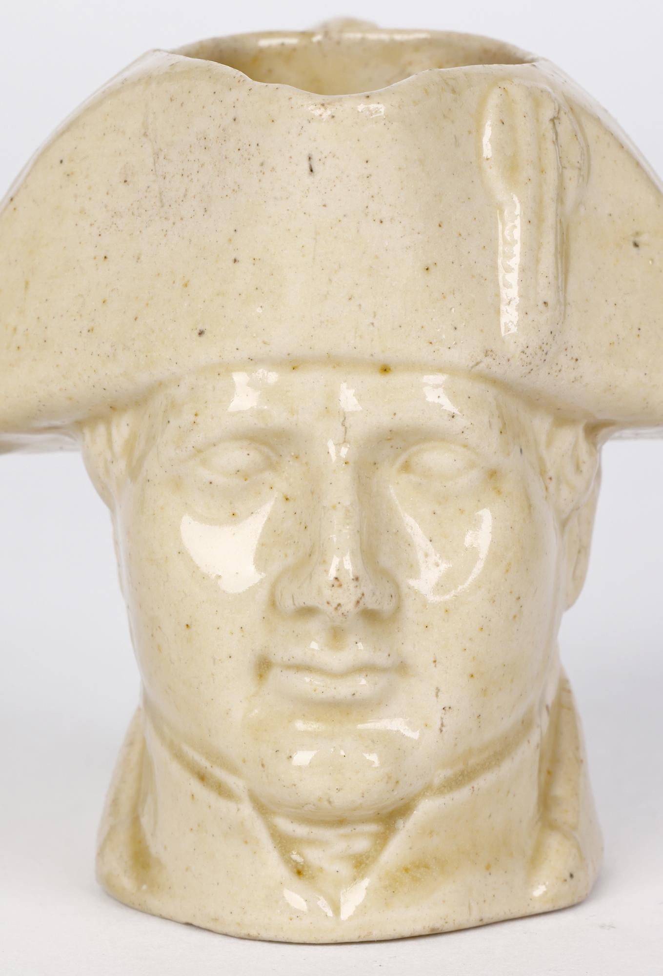 Seltener antiker Salzglasierter Milchkännchen aus frühem Steingut, modelliert als Büste Napoleons von Stephen Green, Lambeth, aus der Zeit um 1840. Dieser entzückende, kleine Krug ist mit dem Kopf von Napoleon modelliert, dessen Kragen den unteren