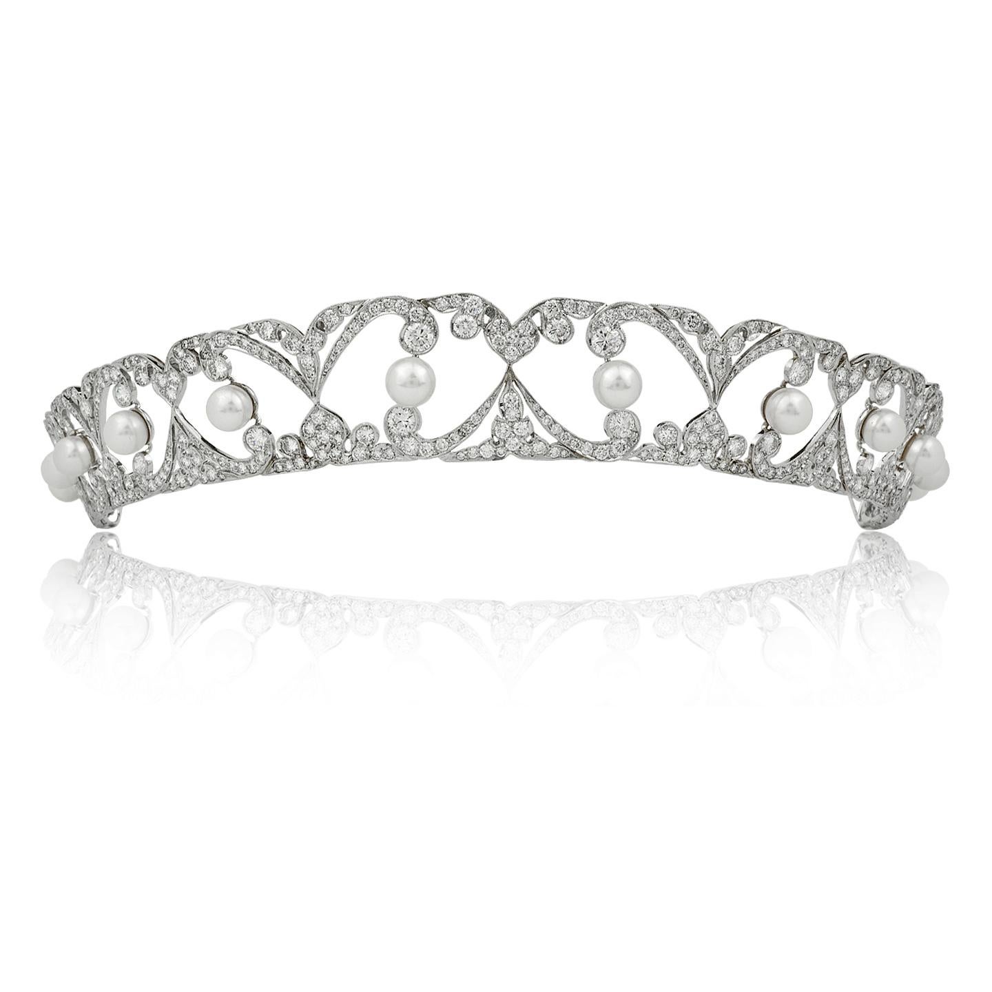 Eine elegante Stephen Russell Platin-Tiara mit Diamanten und Perlen im edwardianischen Design, entworfen als eine Reihe von gegenüberliegenden Bögen im arabesken Stil des 18. Jahrhunderts, besetzt mit 10 perfekten weißen Perlen.
Diamant- und