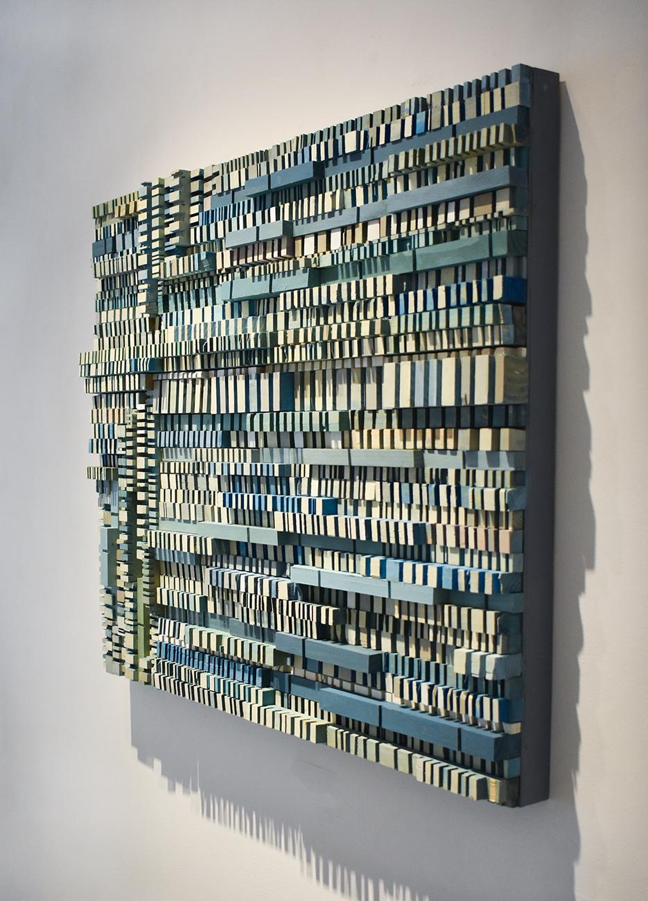 Abstract three-dimensional wall sculpture, acrylic and wood on panel 
Carved strips of wood dyed and painted in shades of light blue, teal, aqua, white and grey 
30 x 36 x 2.5 inches, can be oriented vertically or horizontally 
Art is wired with
