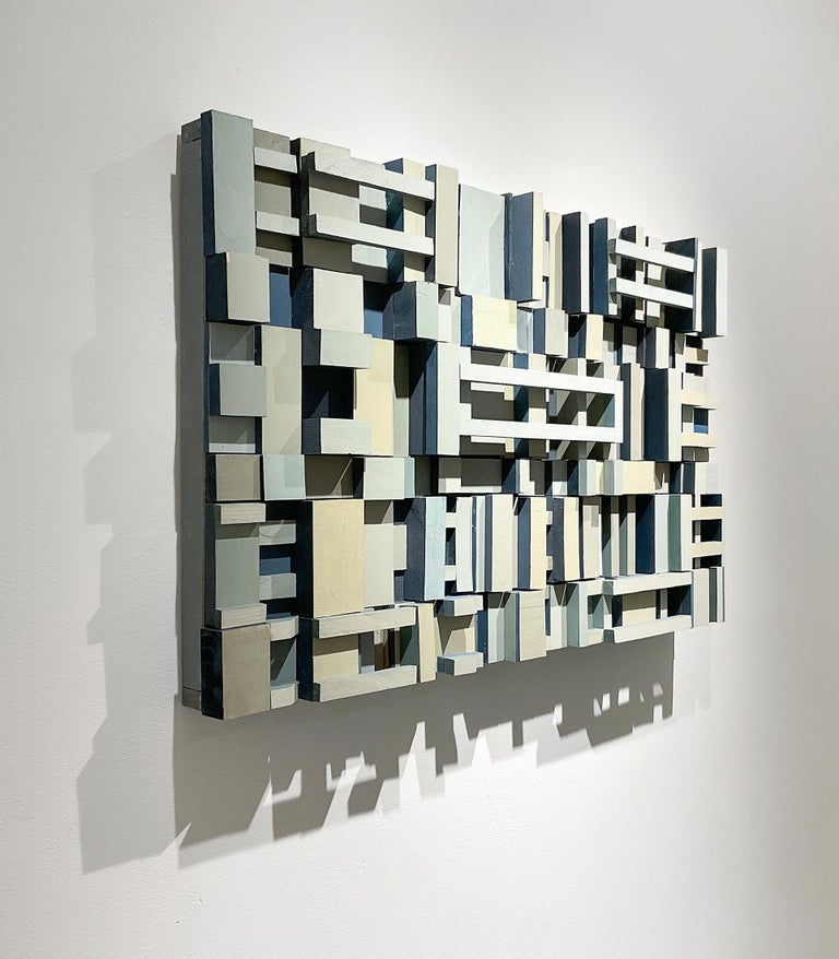 Abstract geometric three-dimensional wood wall sculpture in pale grey, light blue, light taupe, and beige, with accents of stormy blue  
