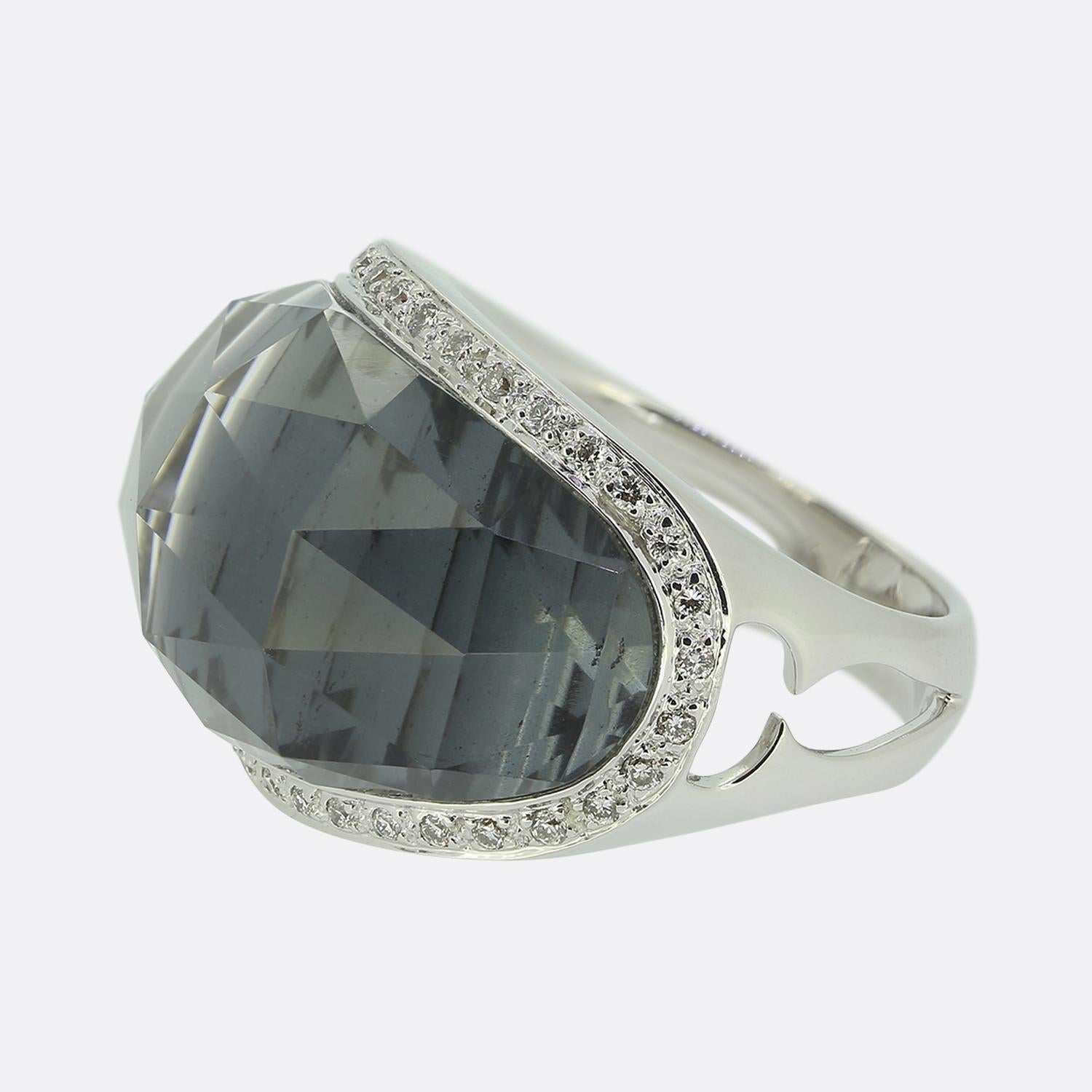 This is an 18ct white gold diamond ring from renowned jewellery designer Stephen Webster. The ring features a large quartz with a black backing surrounded by a frame of round brilliant cut diamonds.

Condition: Used (Very Good)
Weight: 14.1