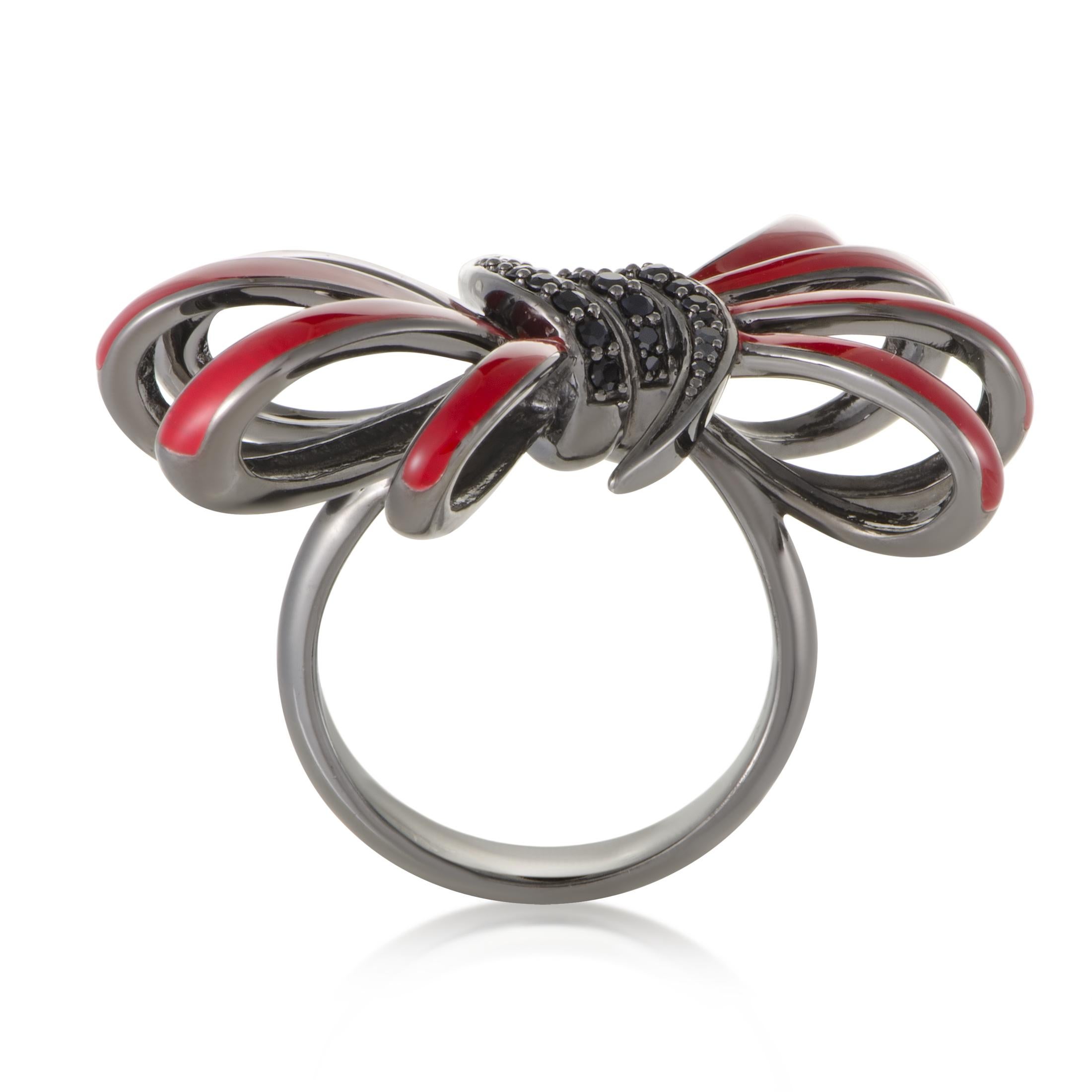 The beautifully marvelous motif of a bow is artistically presented in fiery red enamel to produce an absolutely stunning contrast against the polished black rhodium-plated silver and captivating black sapphires, that amount to 0.26 carats, in this