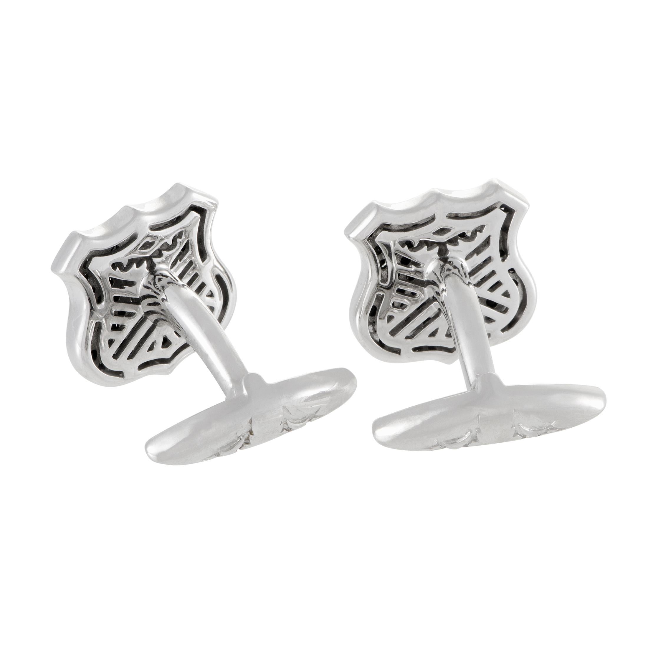 Designed in the attractive shape of shields and set with striking black sapphires weighing in total 1.73 carats, these fascinating silver cufflinks from Stephen Webster are exquisitely crafted items from the renowned ?Highwayman? collection.
