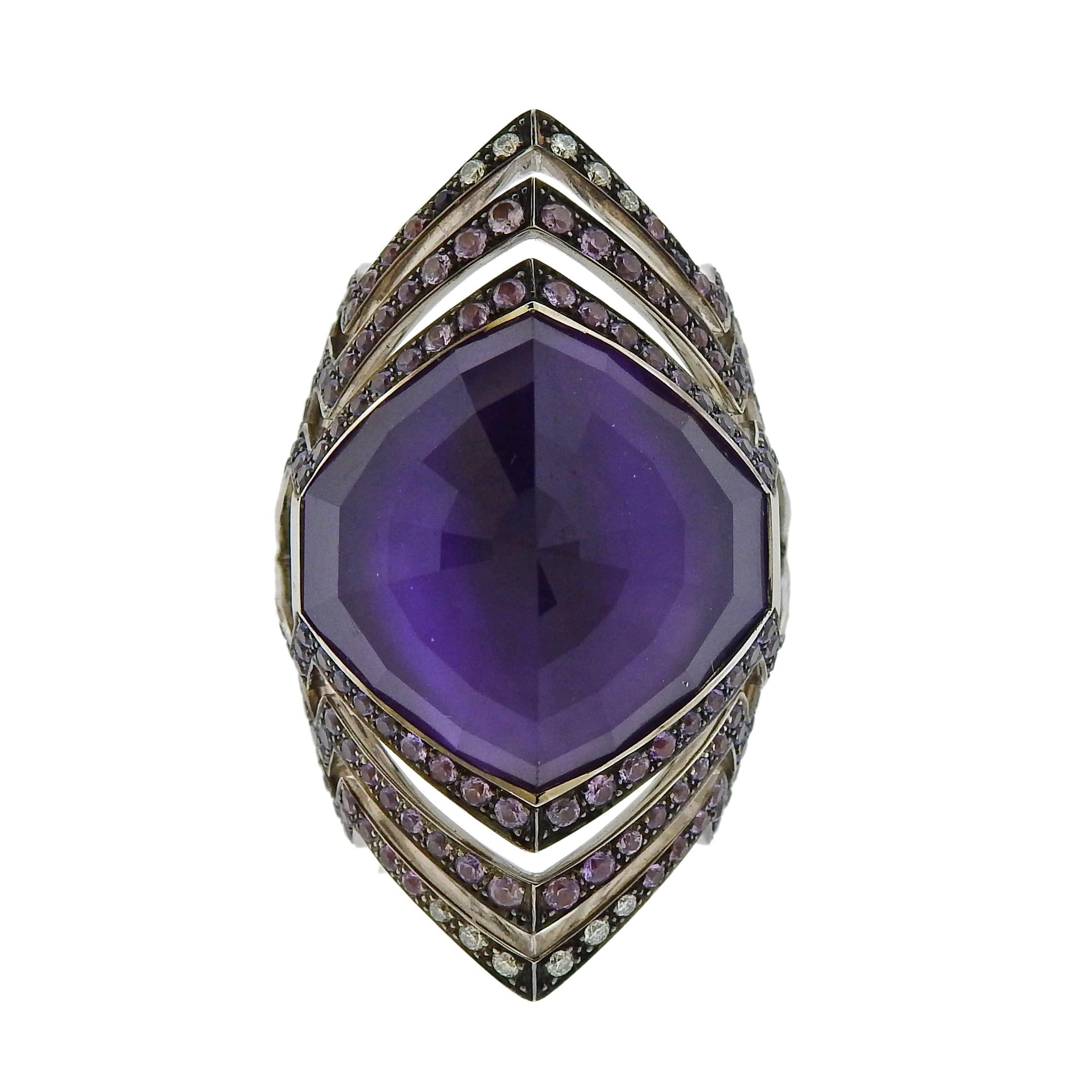 Brand new 18k gold Lady Stardust ring by Stephen Webster, set with amethyst approx. 0.09ctw in diamonds and approx. 1.77ctw in purple sapphires.  Retail $11500. Comes with original packaging. Ring sizes 6 or 7.5 available, ring top - 35mm wide.