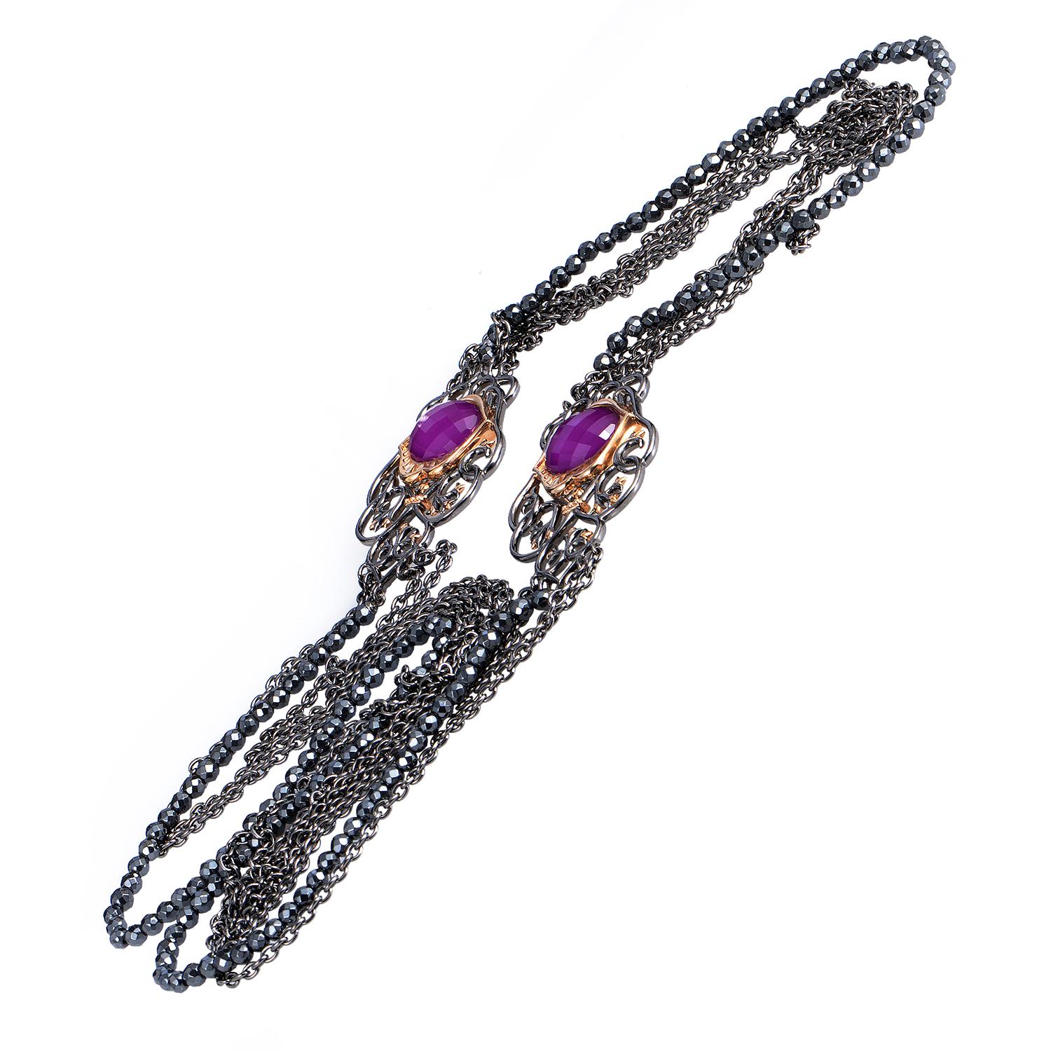 Lined with gorgeous hematite stones and boasting spellbinding décor, this delightful necklace from Stephen Webster is made of elegant silver which forms enchanting filigree patterns around the shark jaws motifs where sugilite and quartz stones