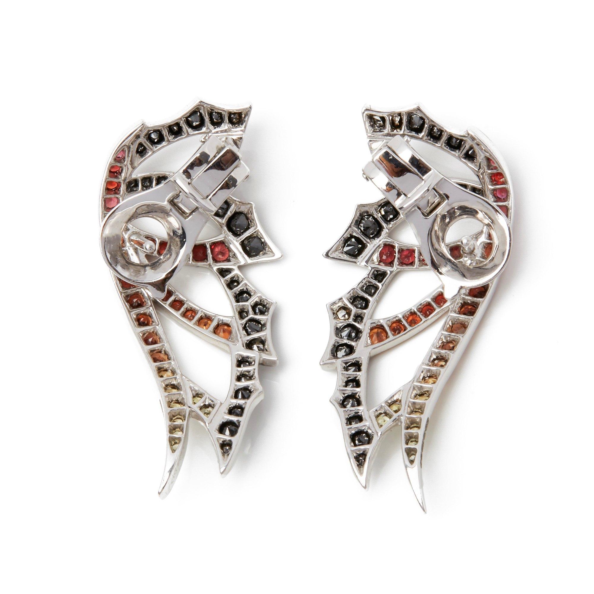 These earrings by Stephen Webster are from his Magnipheasant collection and feature a mix of graduated orange and yellow sapphires along with black diamonds. Set in 18k white gold and with a post and omega back fitting. Complete with Xupes