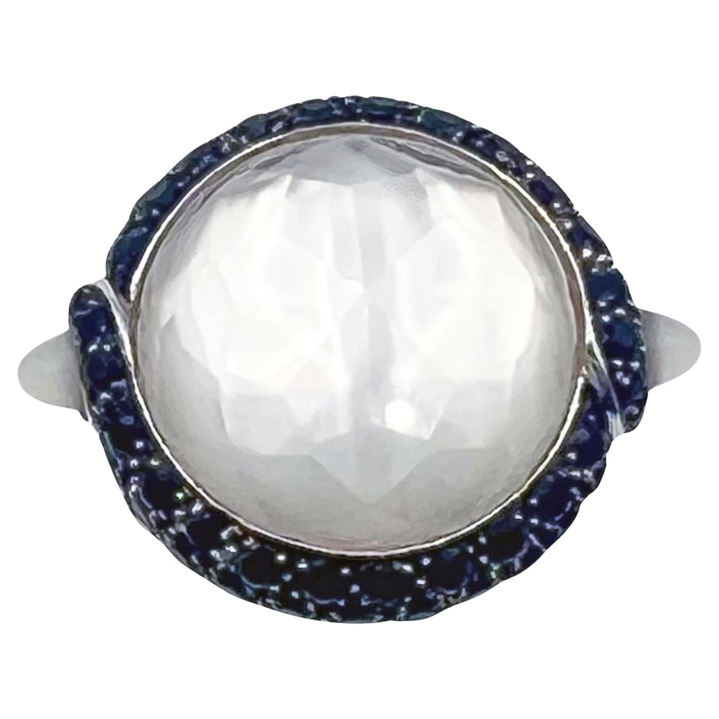 Stephen Webster ring in 18k white gold, centering faceted rock crystal backed by mother-of-pearl and surrounded by black sapphires, flanked by a bullet-shaped chrysoprase on either side.  Rock crystal measures 18mm in diameter and weighs 20.59