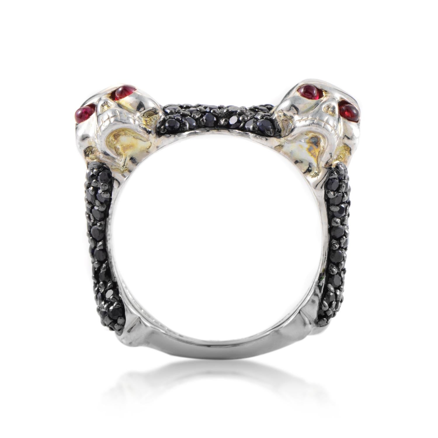 Designed for men with strong focus on offbeat masculine elements, this impressive Stephen Webster ring is made of silver and boasts eye-catching decoration in form of two skulls set with four rubies totaling 0.26ct, surrounded with 2.80 carats of