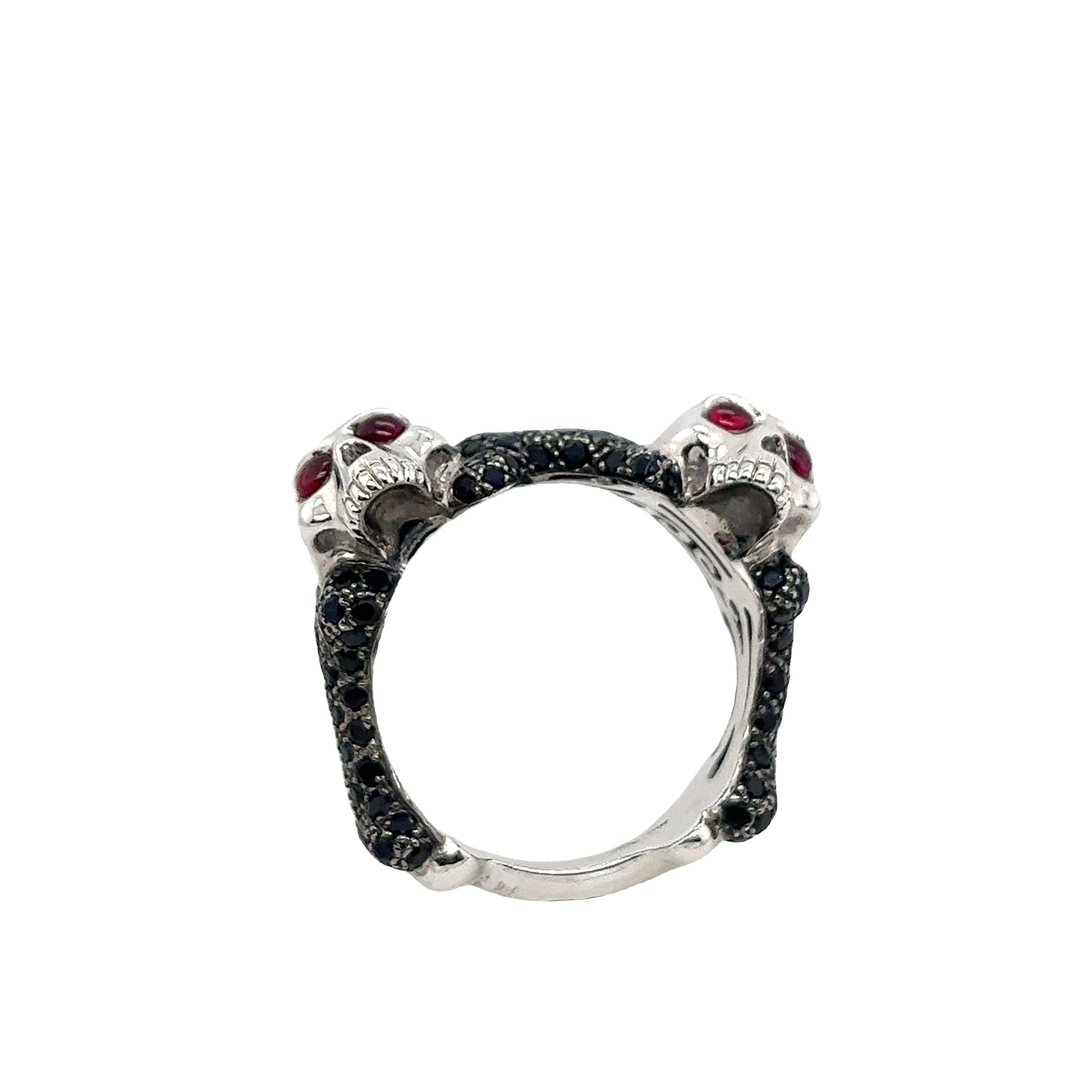 Ein wahres Zeugnis für seine faszinierende Ästhetik, 
Dieser von einem Totenkopf inspirierte Ring ist eine Verkörperung gehobener Raffinesse.
Er ist aus massivem 18-karätigem Weißgold gefertigt. 
Das Totenkopfpaar hat Rubinaugen und der Ring ist mit