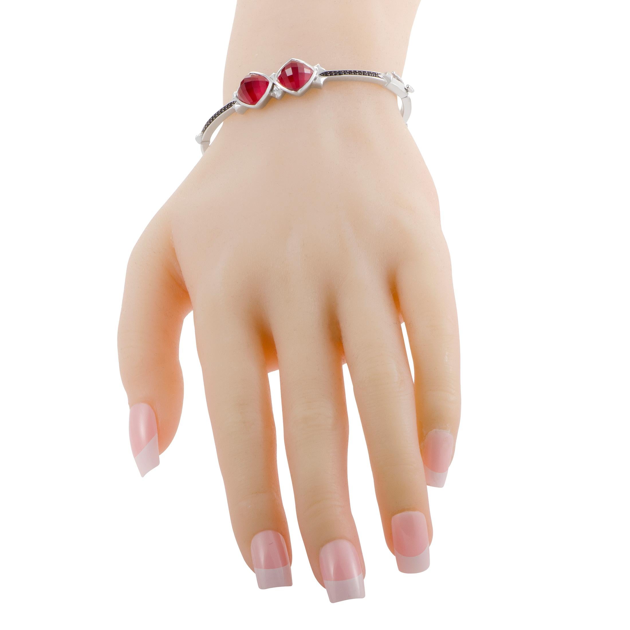 The tasteful blend of compelling gems includes fabulous synthesized coral stones, splendid quartz and stunning black sapphires amounting to 0.23ct in this fantastic bangle from Stephen Webster's Superstud collection which is made of white