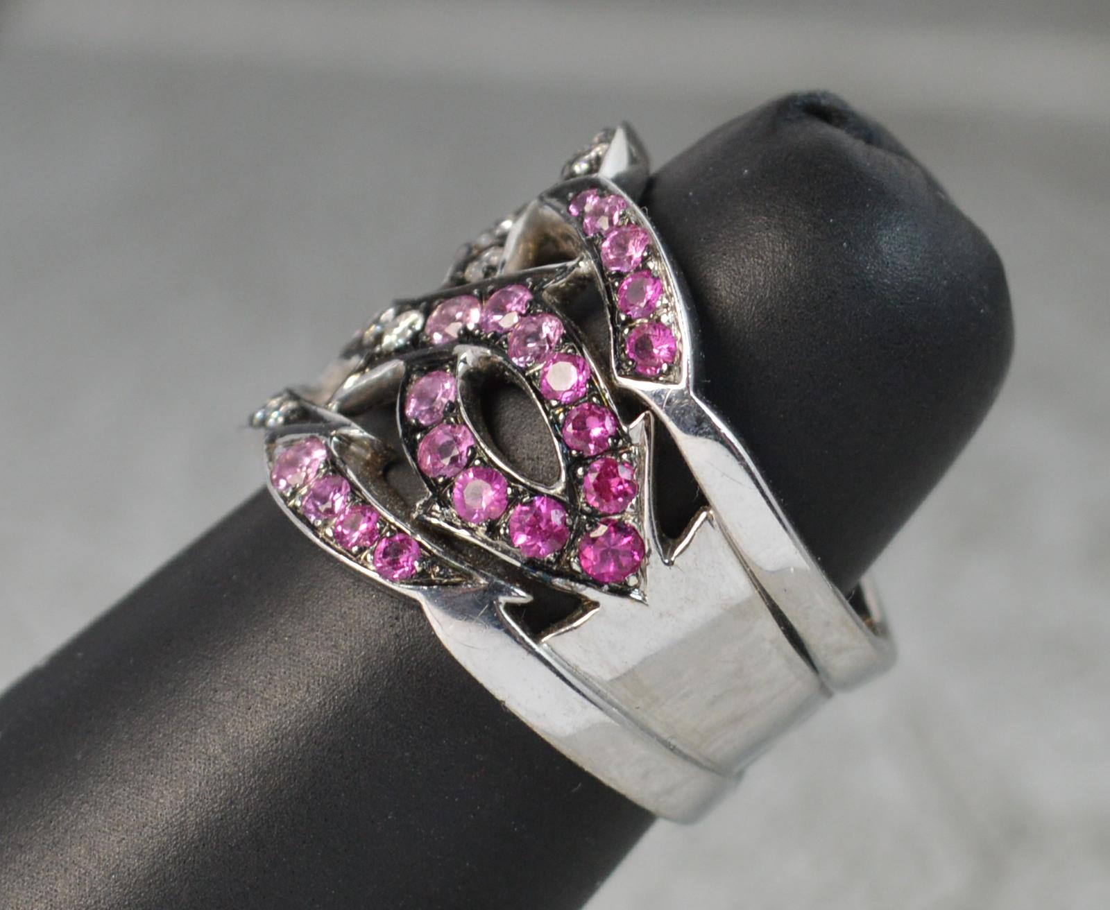 A very stylish Stephen Webster designer ring, part of the Tattoo range.
Solid and heavy 18 carat white gold example.
The front designed with graduated colour pink sapphires and white diamonds in blackened grain settings. Striking shape and impact.
