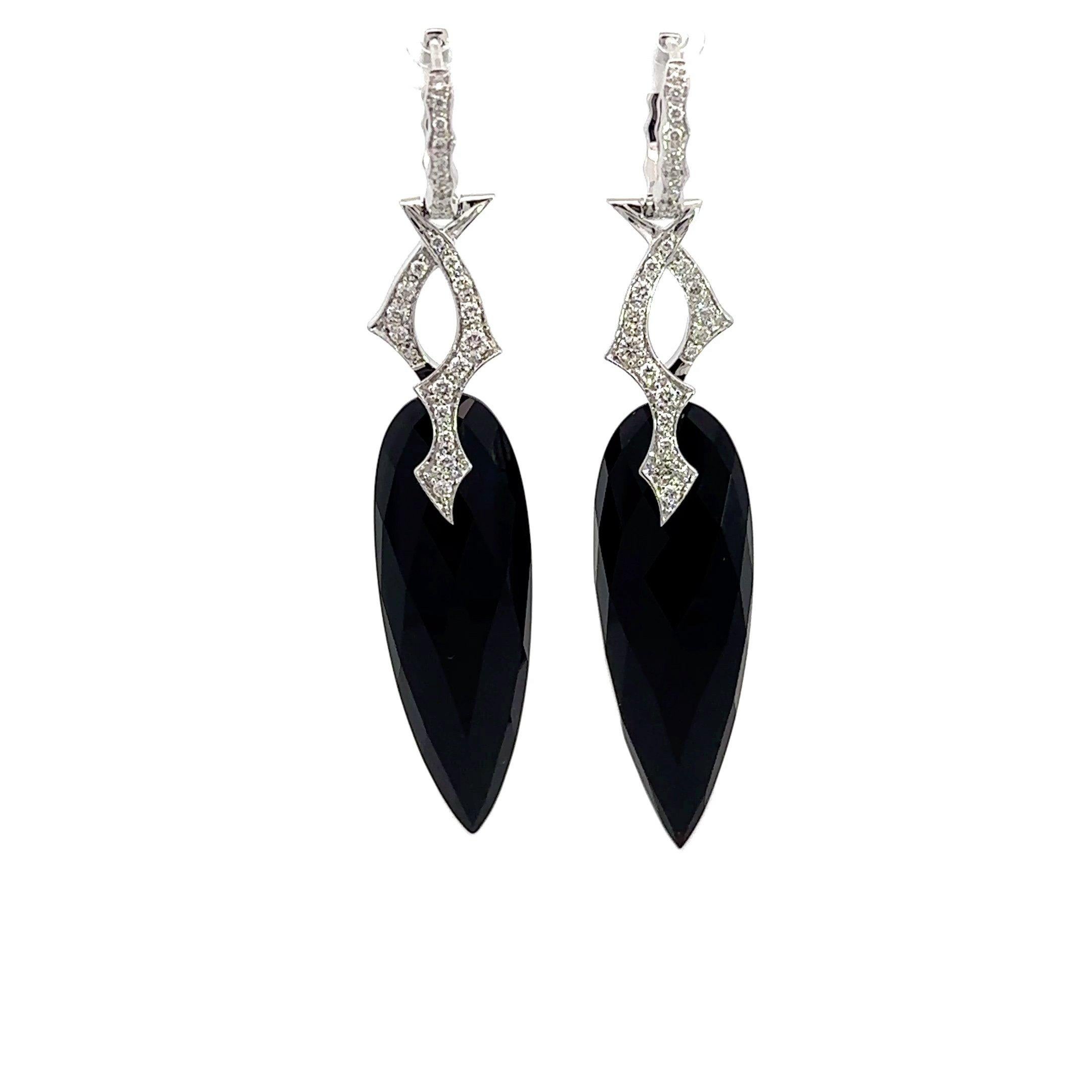 These Stephen Webster earrings feature vine motif diamond tops in 18KT white gold with approximately .78CT round diamonds suspending a faceted pear-shaped onyx. Each earring is stamped 18K and SW for Stephen Webster, with Stephen Webster maker's
