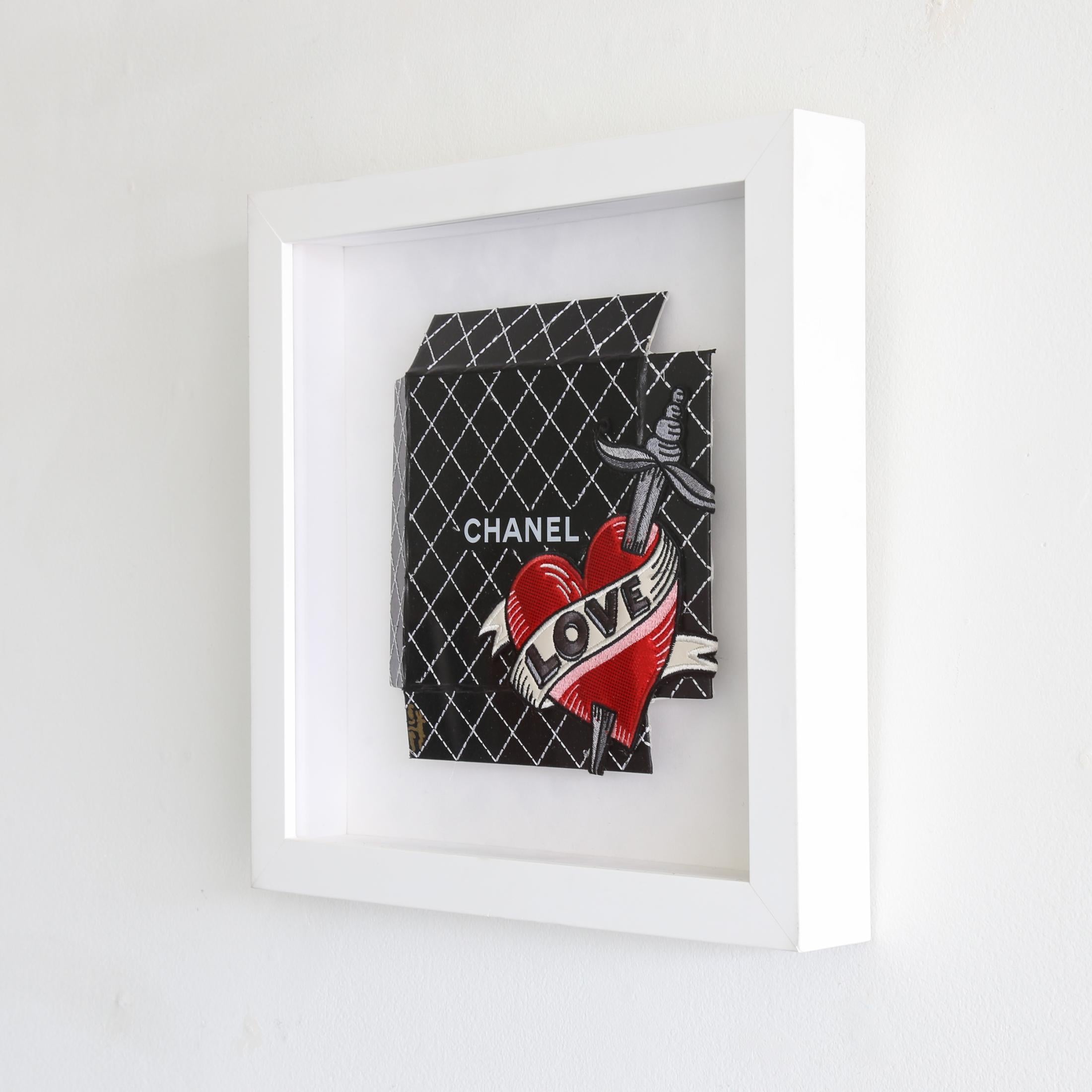 Chanel Love by artist Stephen Wilson is a contemporary black, red, grey, and white embroidered on luxury design box that measures 15.25 x 15.25 and is priced at $1,500.

