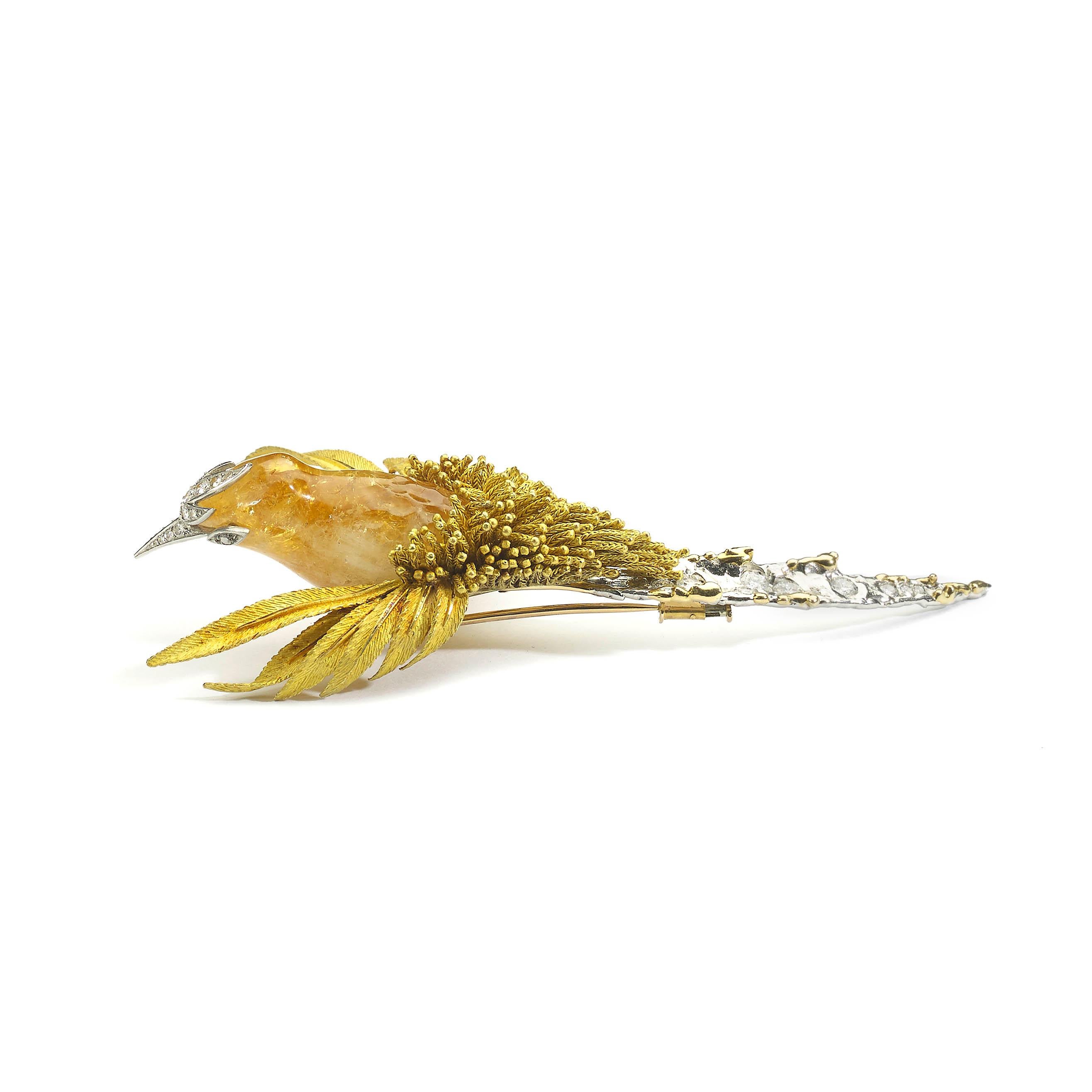 A rare gold, diamond and gem set bird brooch by Sterlé. The gold textured wings are spread as if the bird is in flight. The body is carved out of citrine quartz suspending multi gold tassels above a gold and diamond set tail and back, circa 1965.
