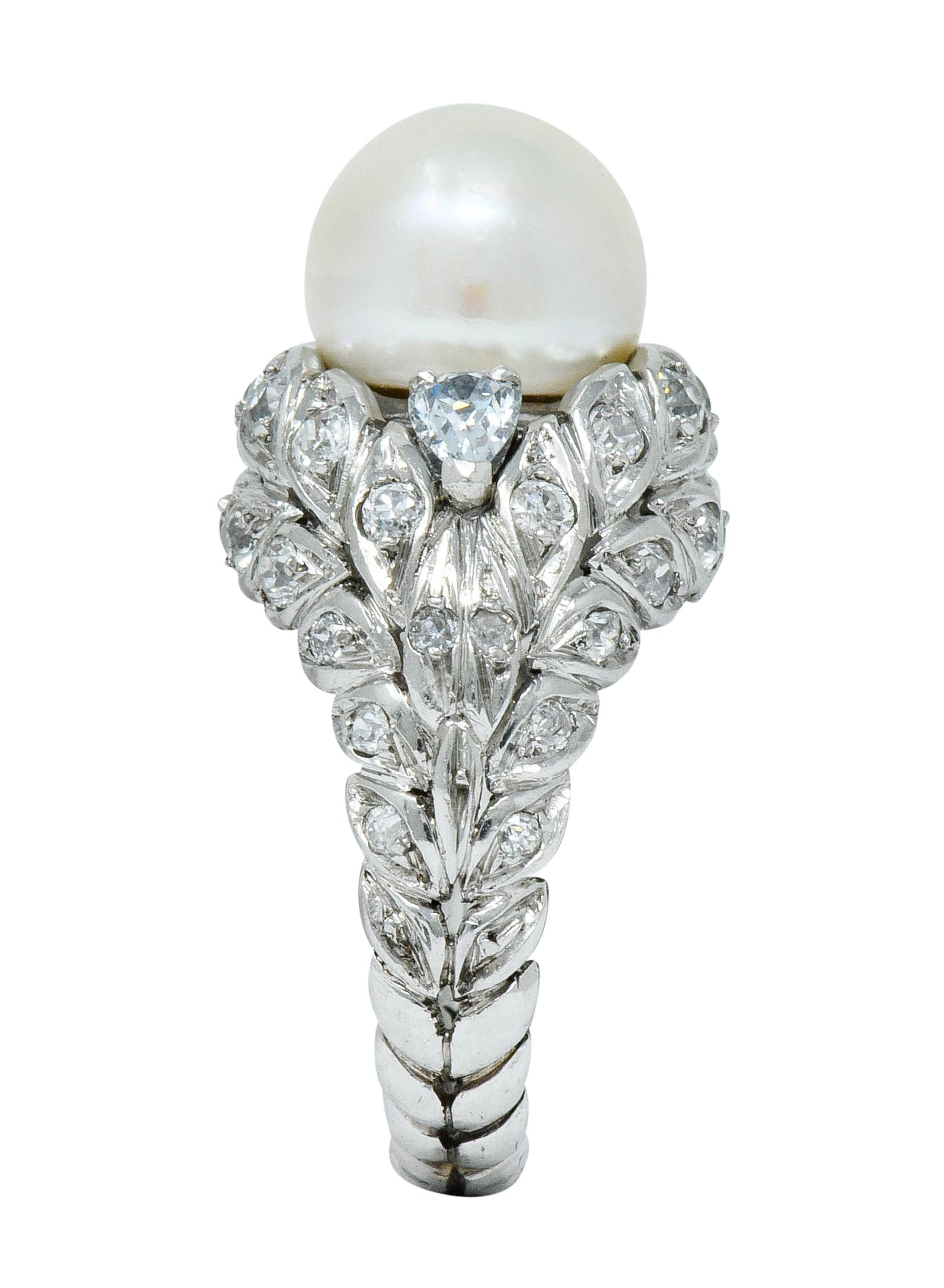 Statement ring is designed as a winding garland of foliate

Centering a large 11.3 mm natural button pearl, cream in body color with strong orient and very good luster

With a pear cut fancy light blue diamond weighing approximately 0.25 carat; VS2