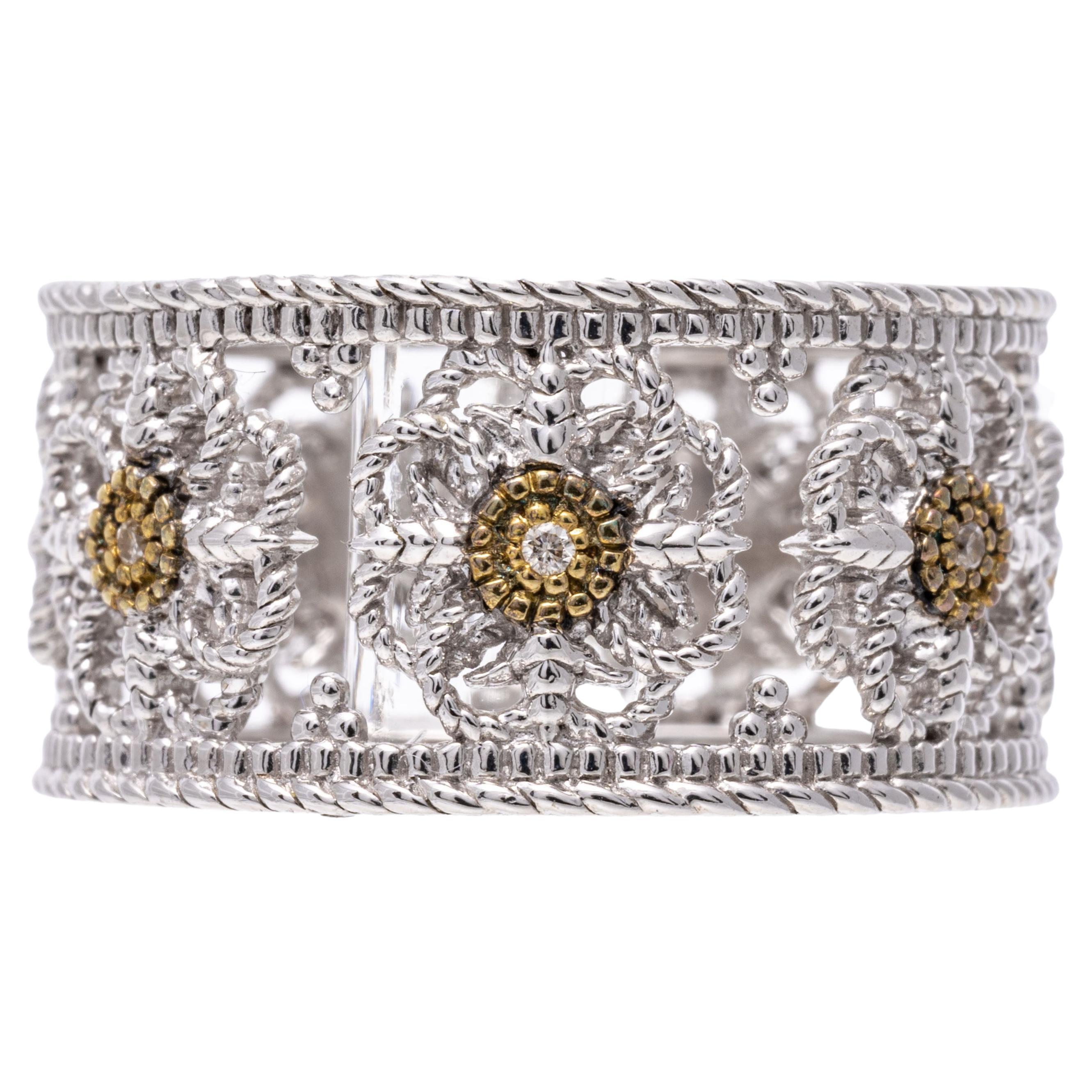 Sterling silver and yellow gold ring. This striking, ultra wide sterling silver eternity band ring has a repeating flower pattern decoration, set in the center with round faceted diamonds, approximately 0.02 TCW and trimmed in yellow gold. The ring