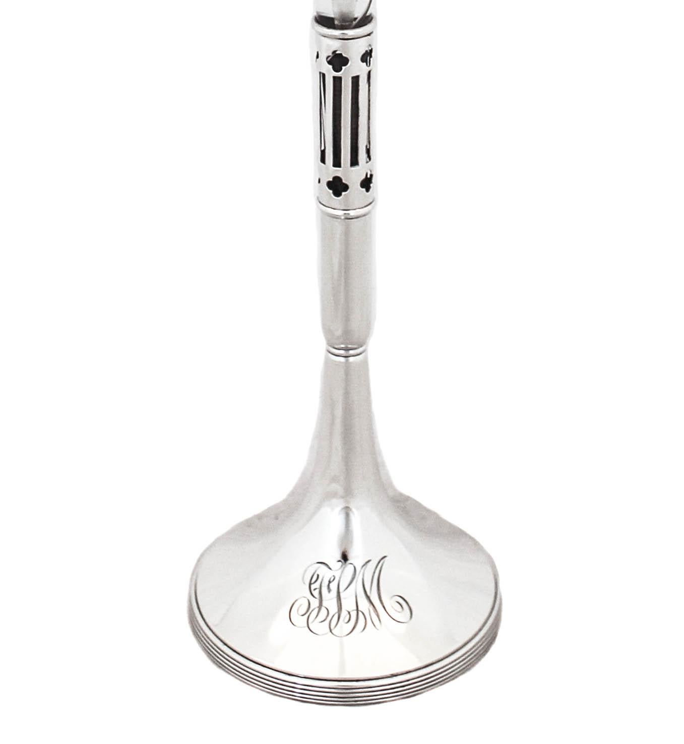 Being offered is a sterling silver bud vase by the William Durgin Silver Company. It has a silver base with a crystal liner that can be removed from the base. The top of the liner is scalloped and looks like a flower. Along the neck, there is an