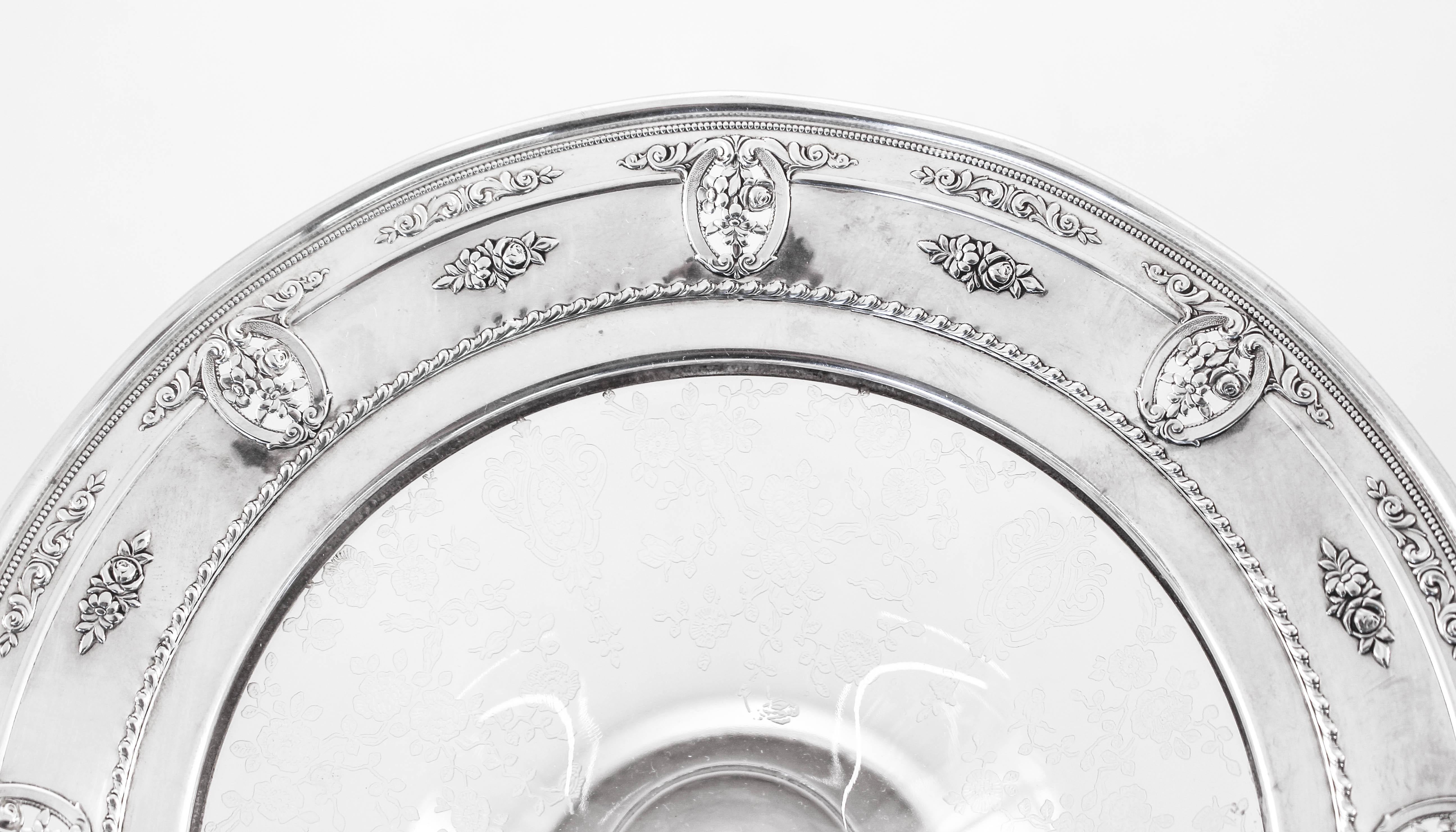 Proud to offer this sterling and crystal compote by Wallace Silversmiths in the Rose-Point pattern. A two-inch sterling border encircles the top while a smaller one encircles the base. There are eight floral motifs with cutout and a fluted edge. The