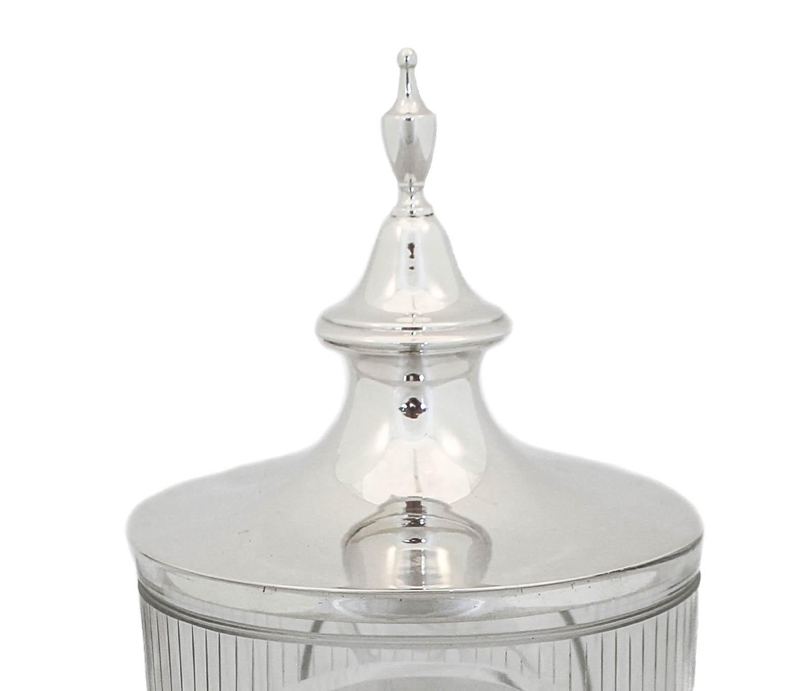 Being offered is a sterling silver and crystal urn by International Silver. The lid is sterling silver and the urn is crystal. The glass has an acid-etched motif; stripes all around and on both sides in a circle a cluster of grapes on their vines. A