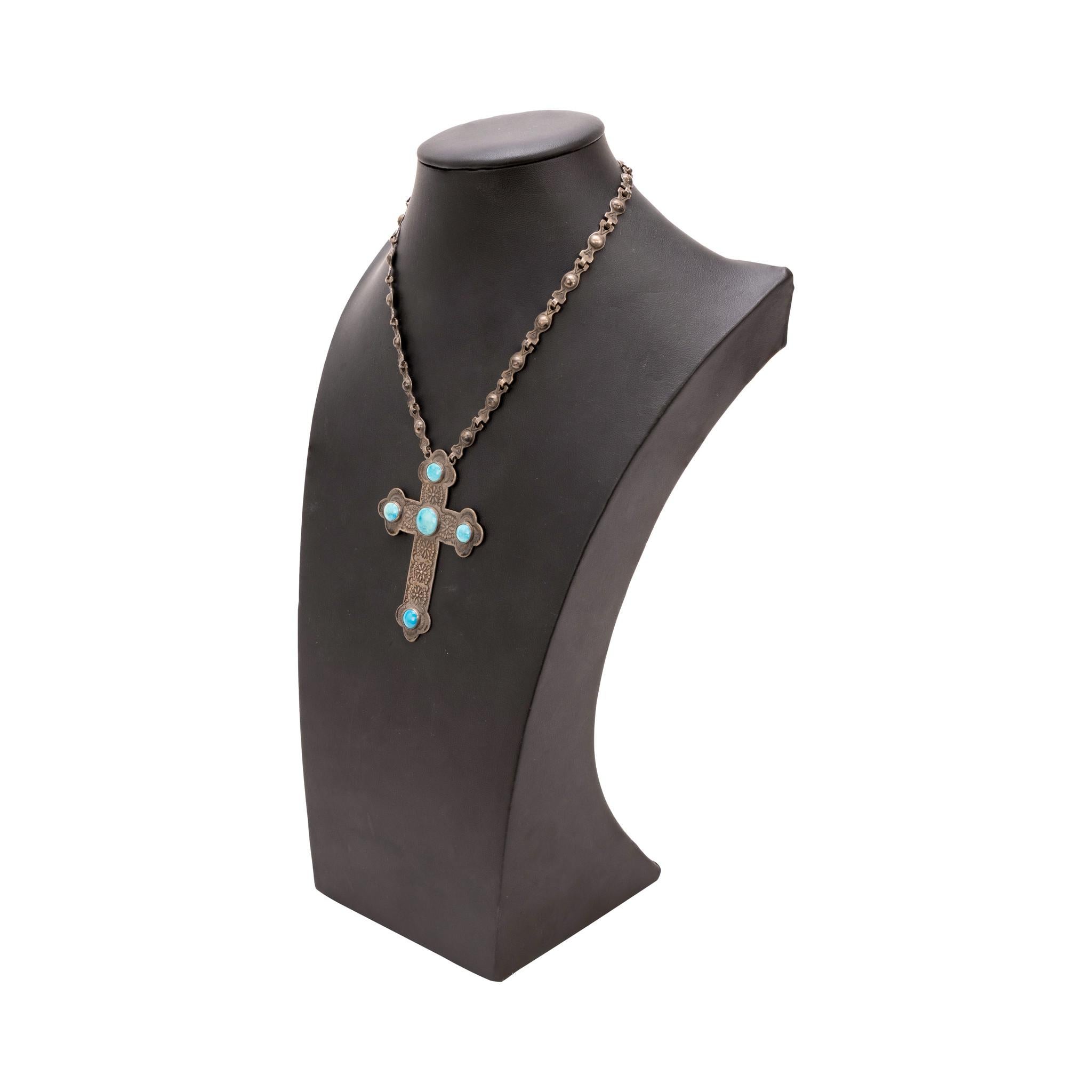 Wunderschöne Halskette mit Kreuz-Anhänger. Großer Kreuzanhänger mit vier hellblauen und weißen Kingman-Türkissteinen. Das Kreuz ist stark mit gestanzten Blumenmustern verziert und an einer individuell gestanzten Gliederkette befestigt. Starke Patina
