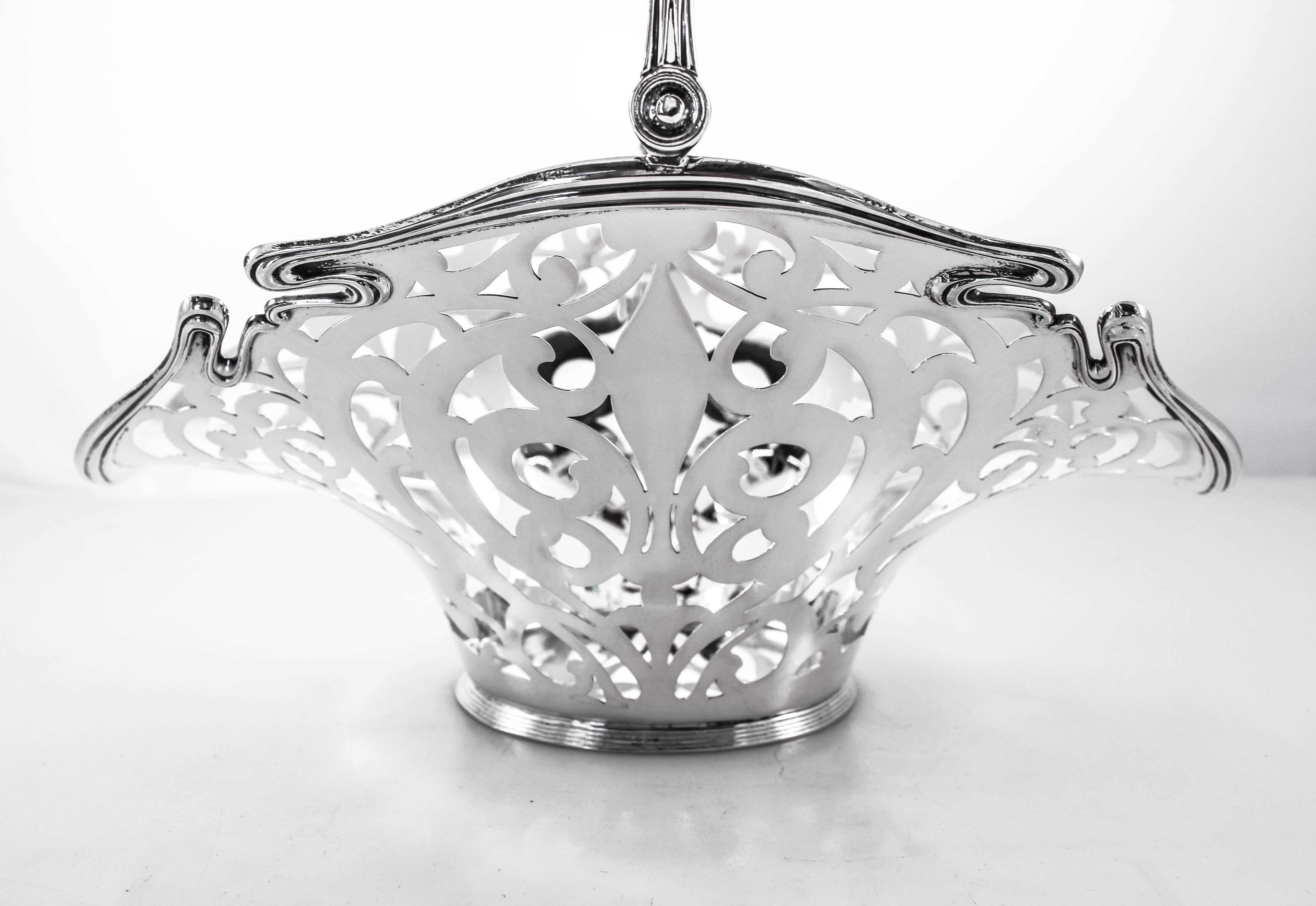 This sterling silver Art Nouveau basket is stunning. Completely reticulated with a scalloped rim, it flares up in the center and dips down on each end. A really unique and eye-catching piece. The handle folds down for easy storage.